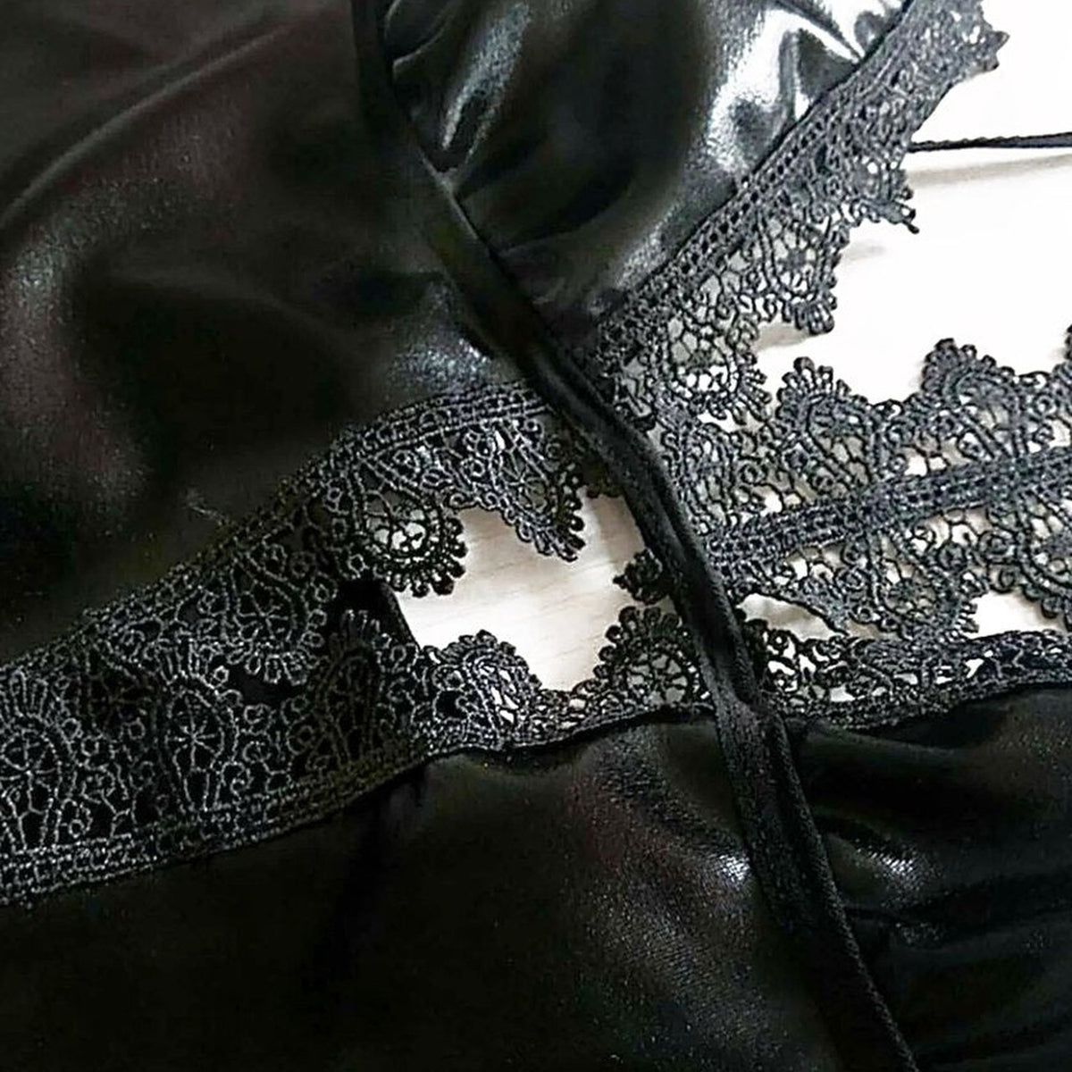 Detail macro de la dentelle noire ajouree et du tissu brillant - Le detail qui retient l'attention