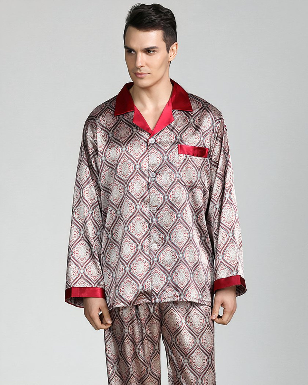 Homme debout de face en pyjama homme satiné beige à motifs, col et poignets rouges