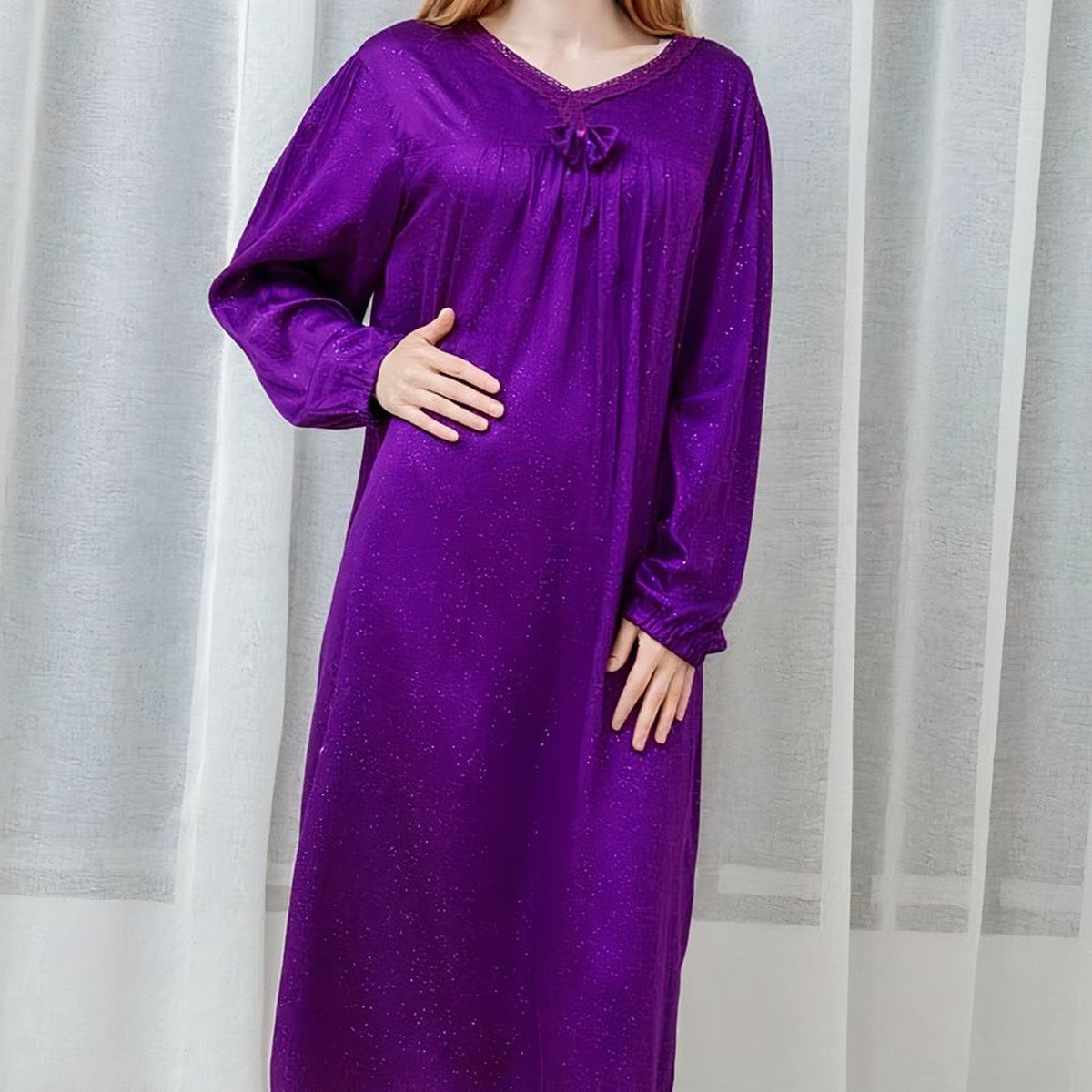 Détail sans visage de la nuisette longue violette, col en V, nœud central et manches longues