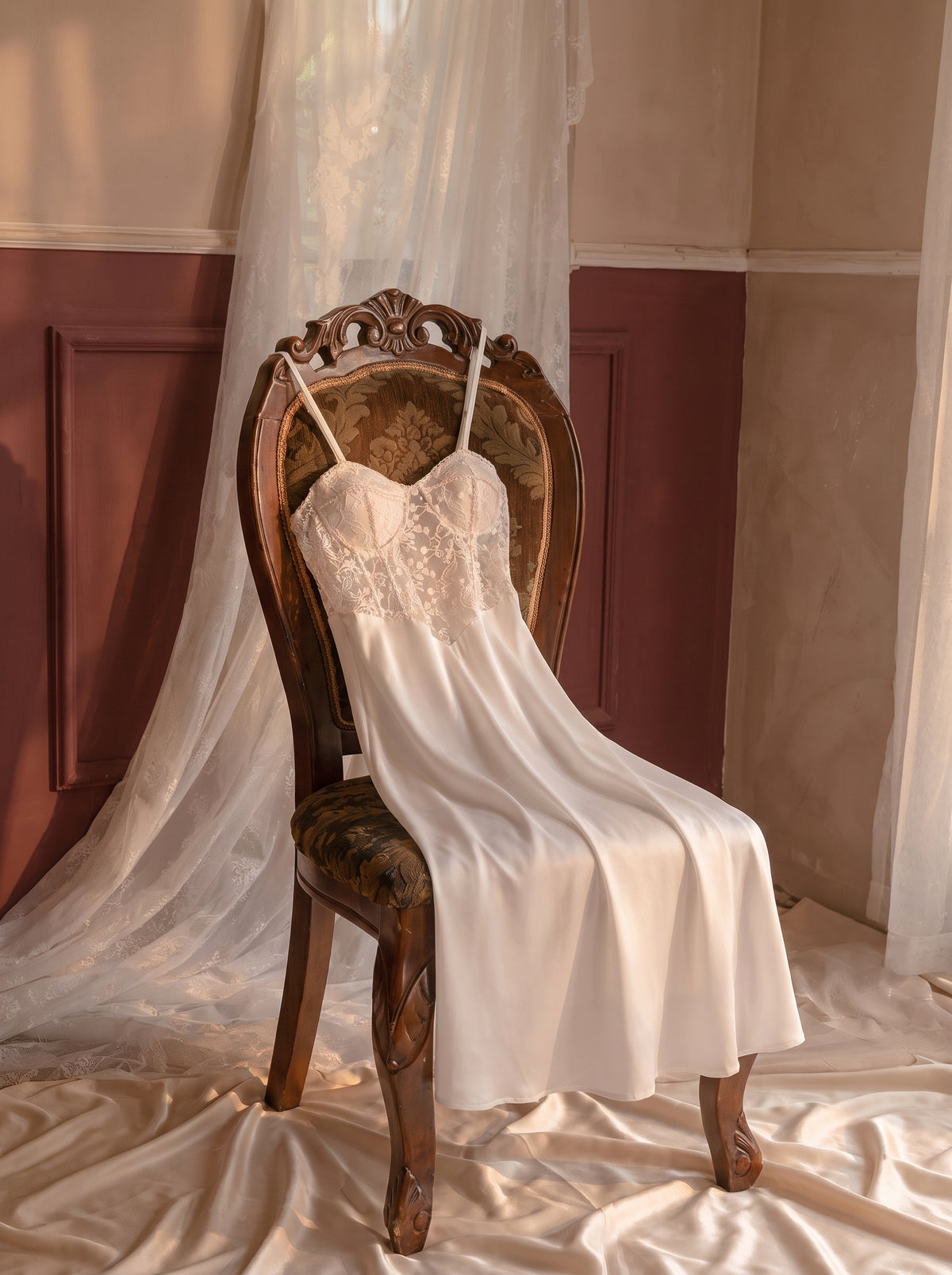 Nuisette blanche en dentelle posee elegamment sur un fauteuil boudoir