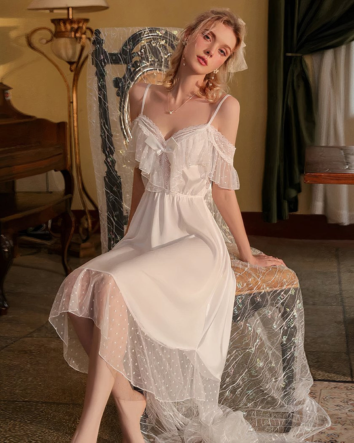 Nuisette blanche mi-longue portée assise de face dans un décor boudoir