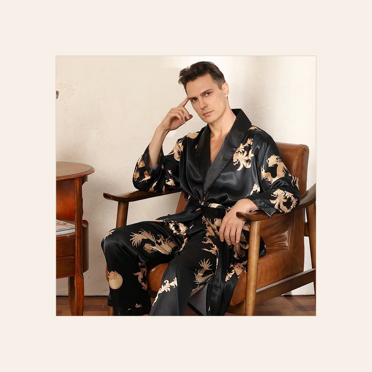 Homme détendu dans un fauteuil avec l’ensemble kimono noir à dragons dorés Image