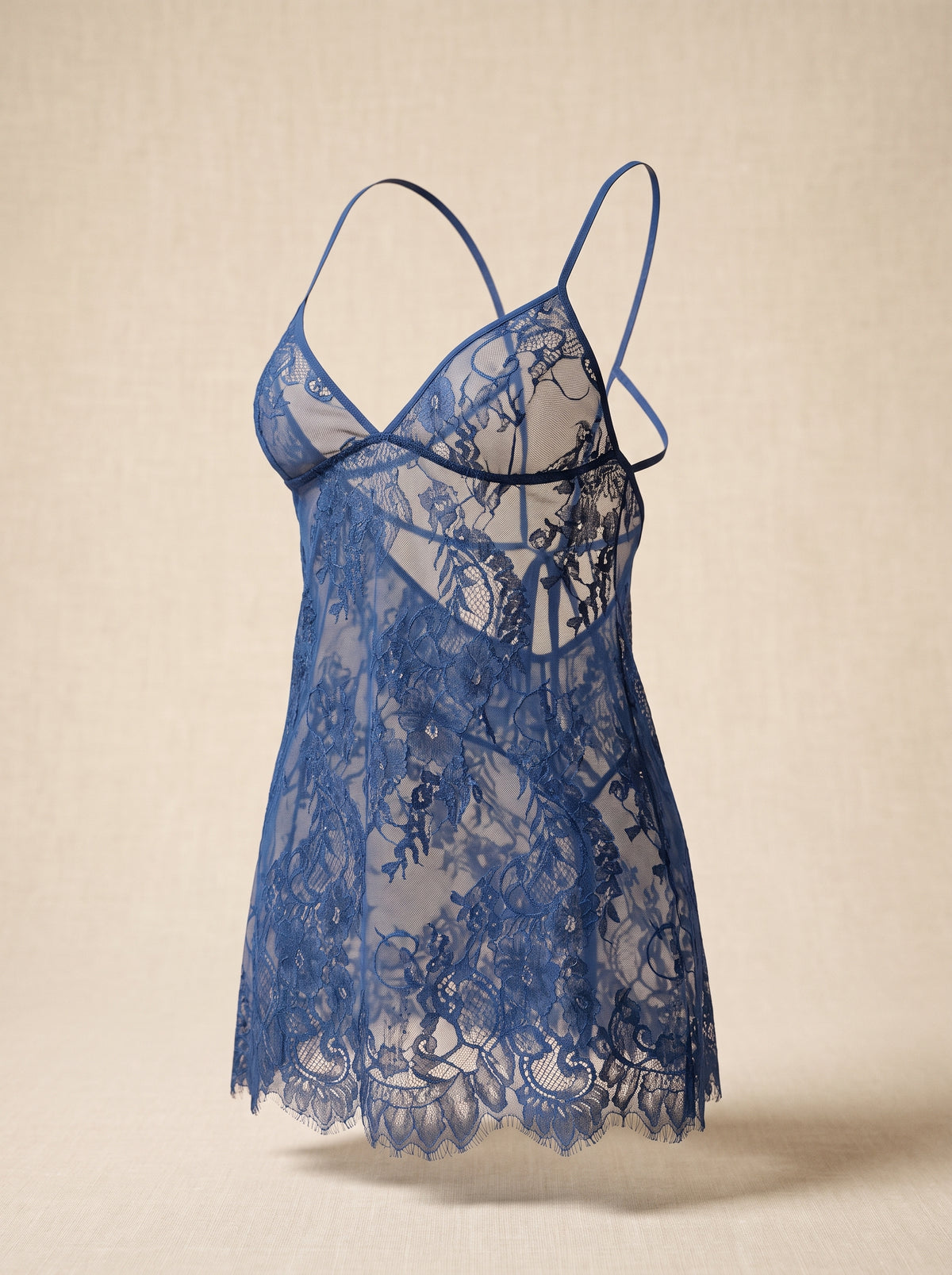 Nuisette en dentelle bleue portee sur mannequin invisible, vue de face, col en V plongeant