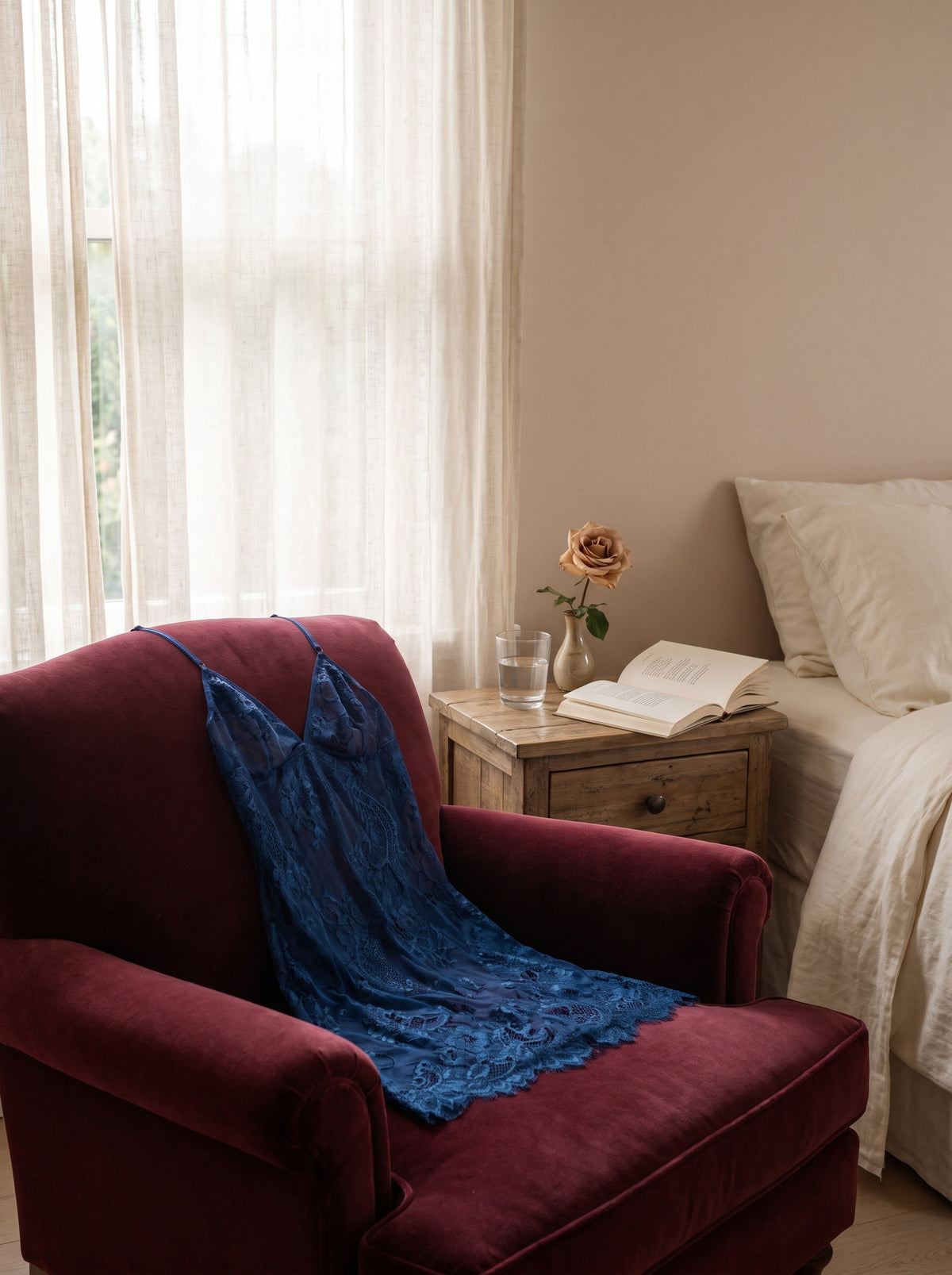 Nuisette en dentelle bleue posee dans un boudoir elegant sur un fauteuil en velours