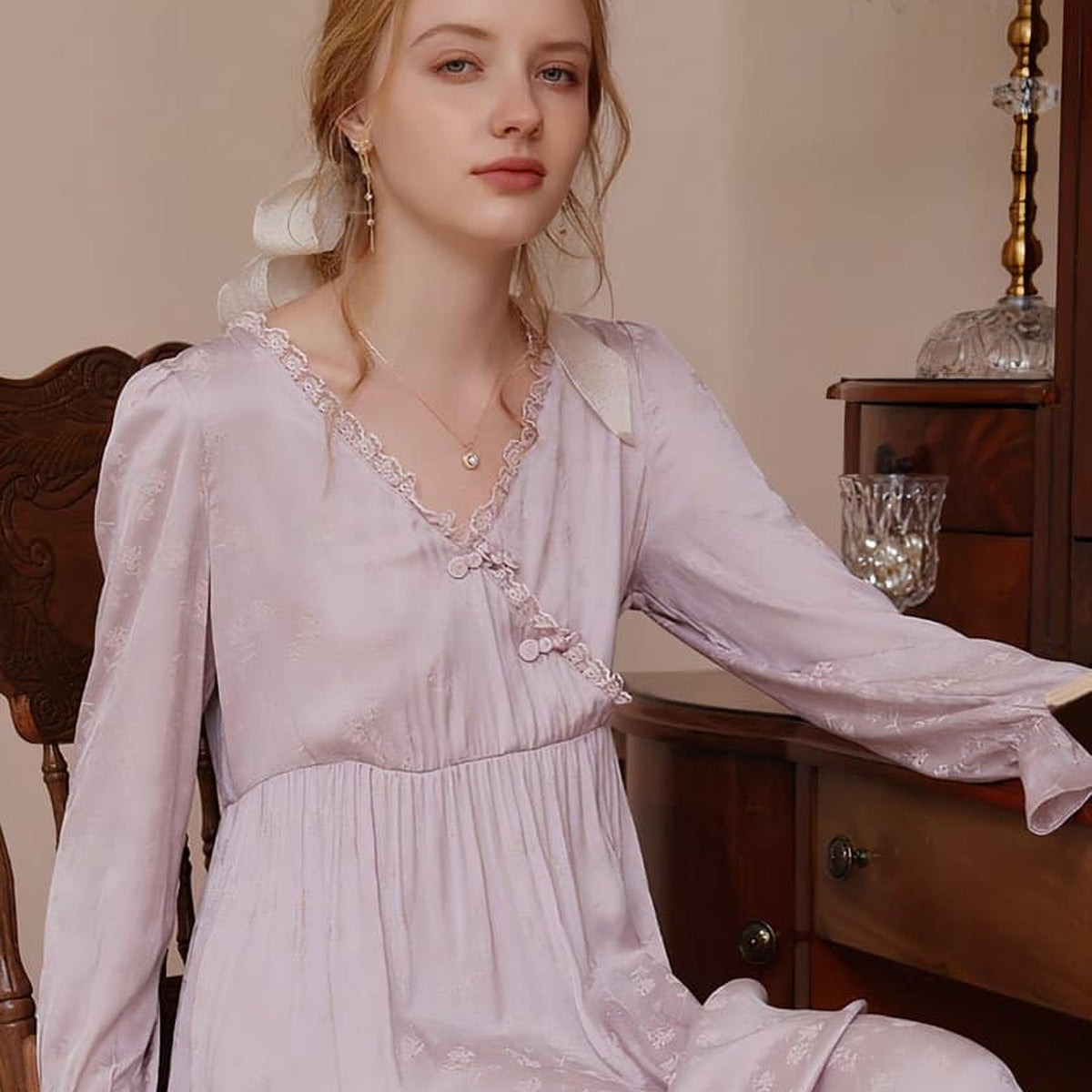 Nuisette rose fluide portée le soir dans un décor de boudoir