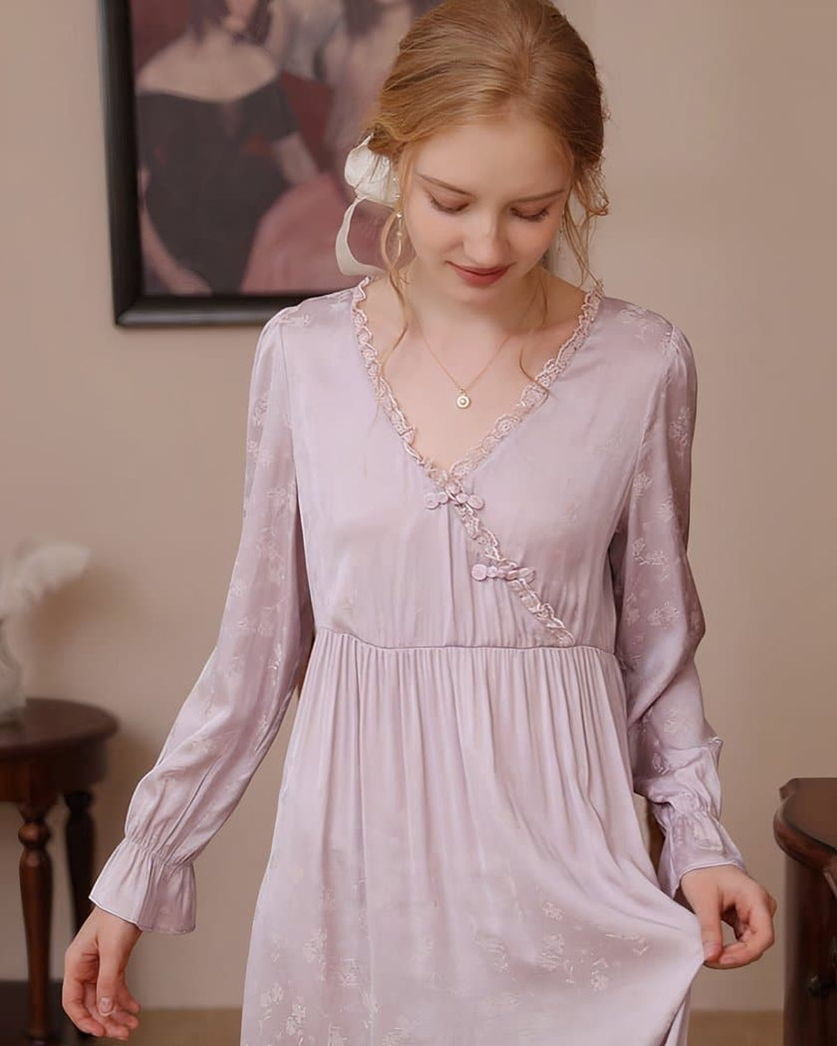 Femme portant la nuisette longue rose à encolure croisée dans un boudoir