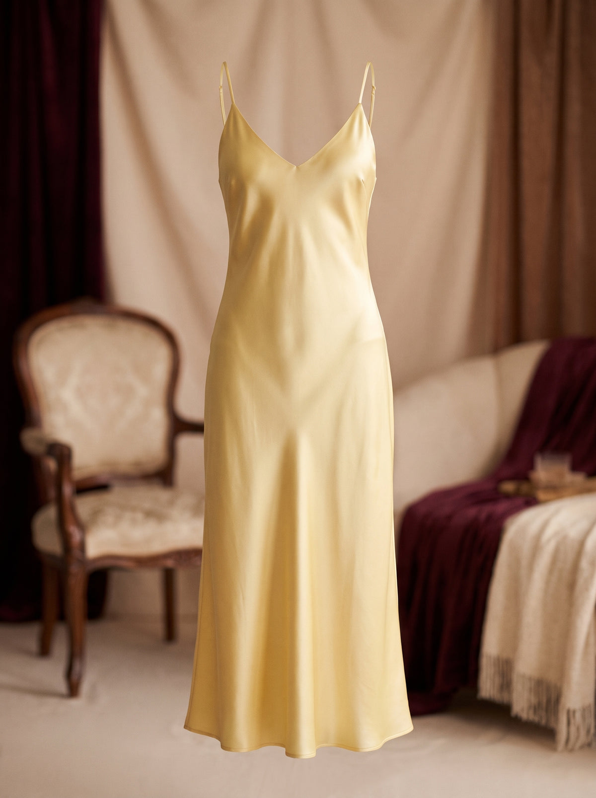 Nuisette sans manche jaune en satin longue portee sur mannequin invisible, vue de face