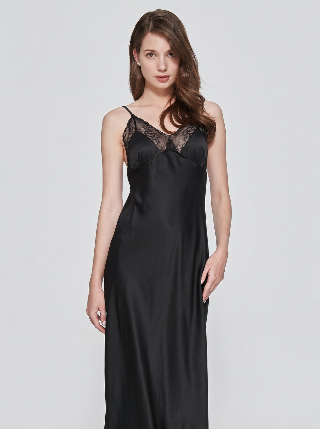 Nuisette longue noire en satin portee de face, tombe fluide du tissu