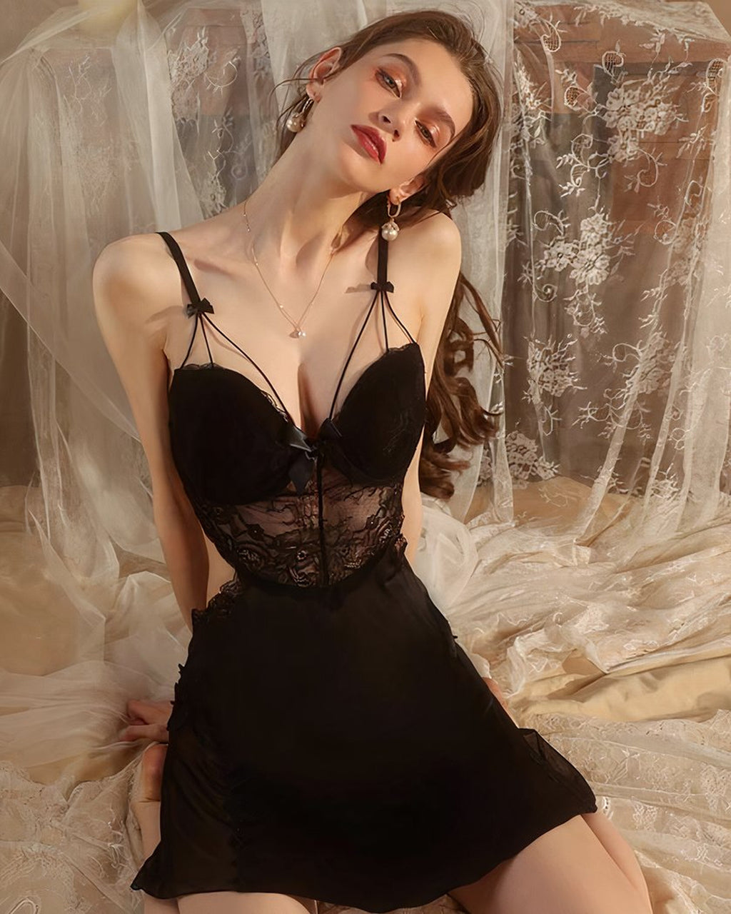 La modèle porte la nuisette sexy noire de face, le décolleté et la taille ajourée visibles