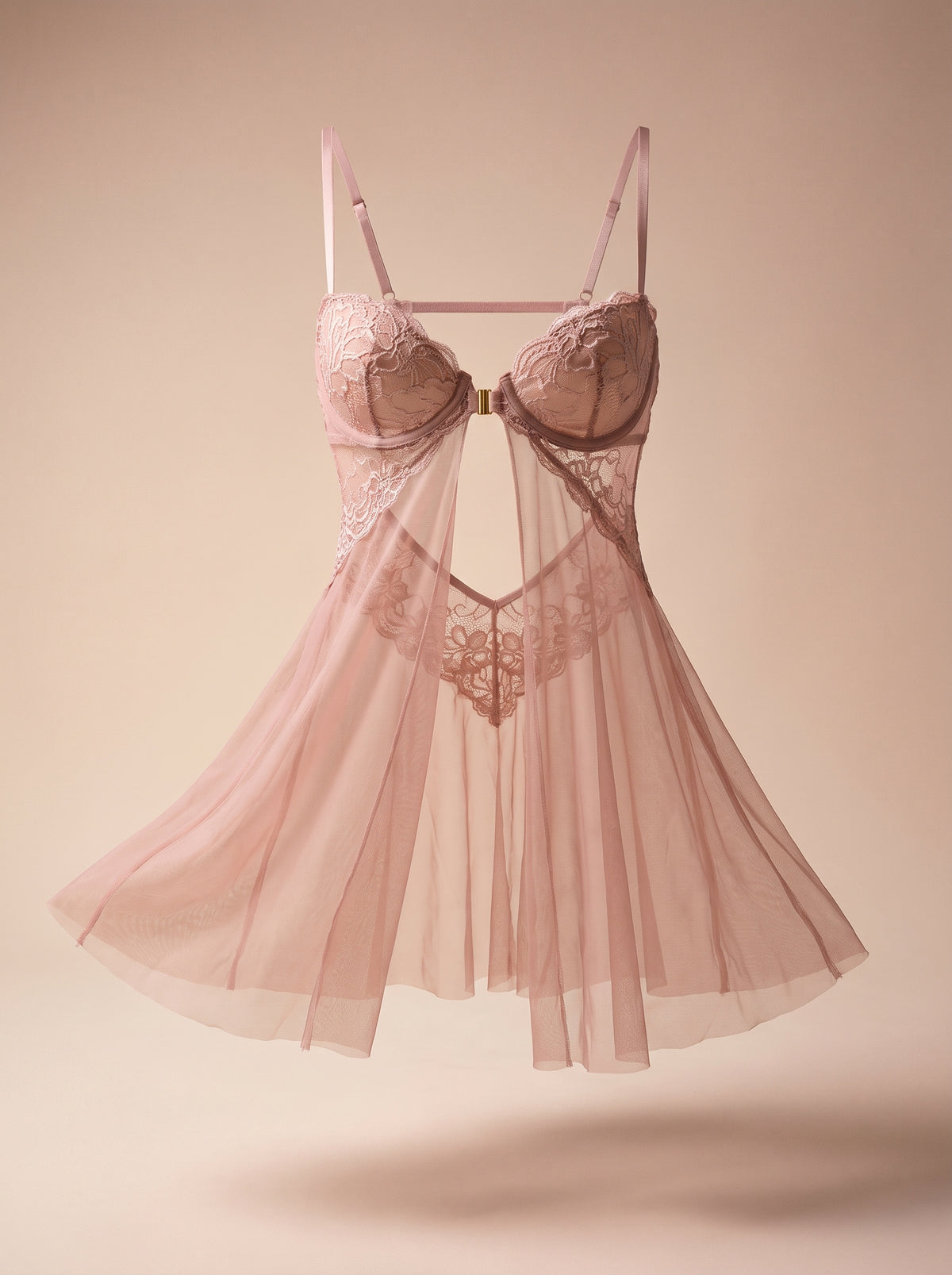 Nuisette babydoll rose sur mannequin invisible, fond uni : on voit par transparence le dos ouvert jusqu’en bas et sa pointe de dentelle