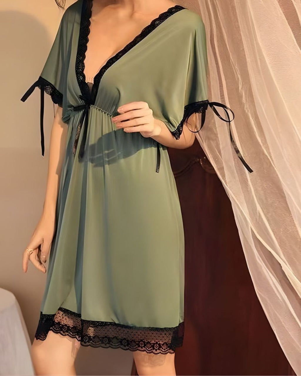 Détail de la dentelle noire et du nœud en ruban de la nuisette verte courte