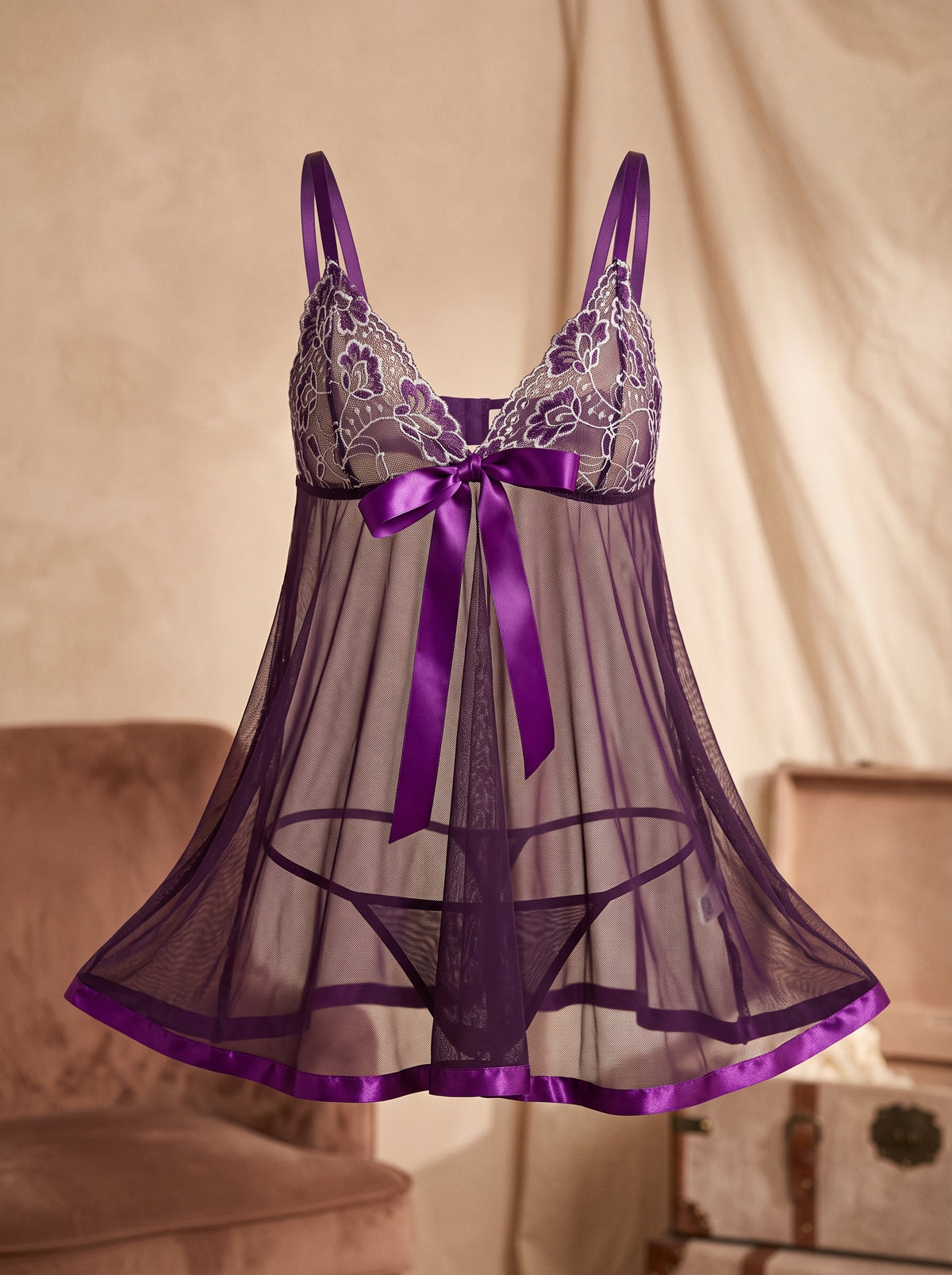 Nuisette violette en voile transparent portee sur mannequin invisible, dentelle brodee blanche, noeud en satin et ourlet brillant