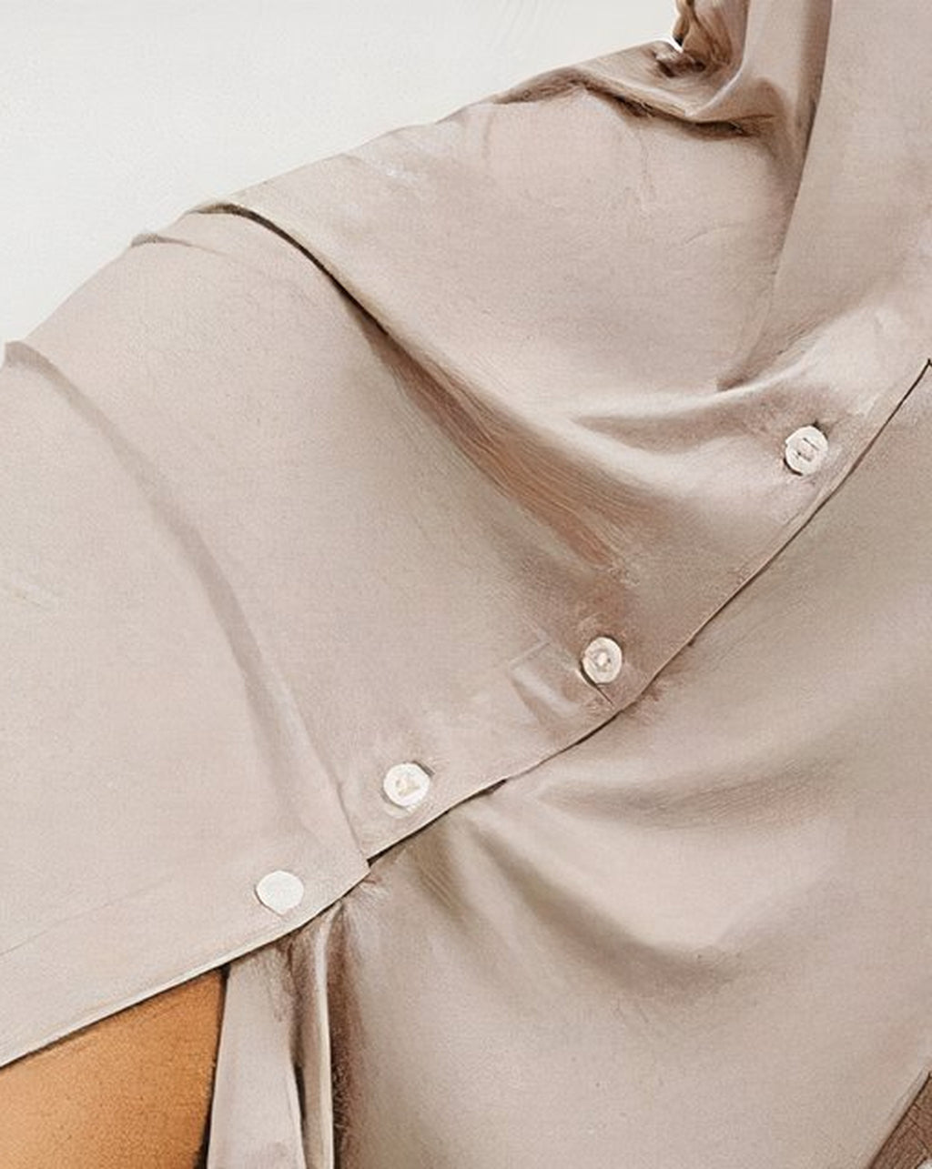 Bas de la chemise de nuit posée sur un plaid tressé, derniers boutons de la patte de devant et ourlet fluide