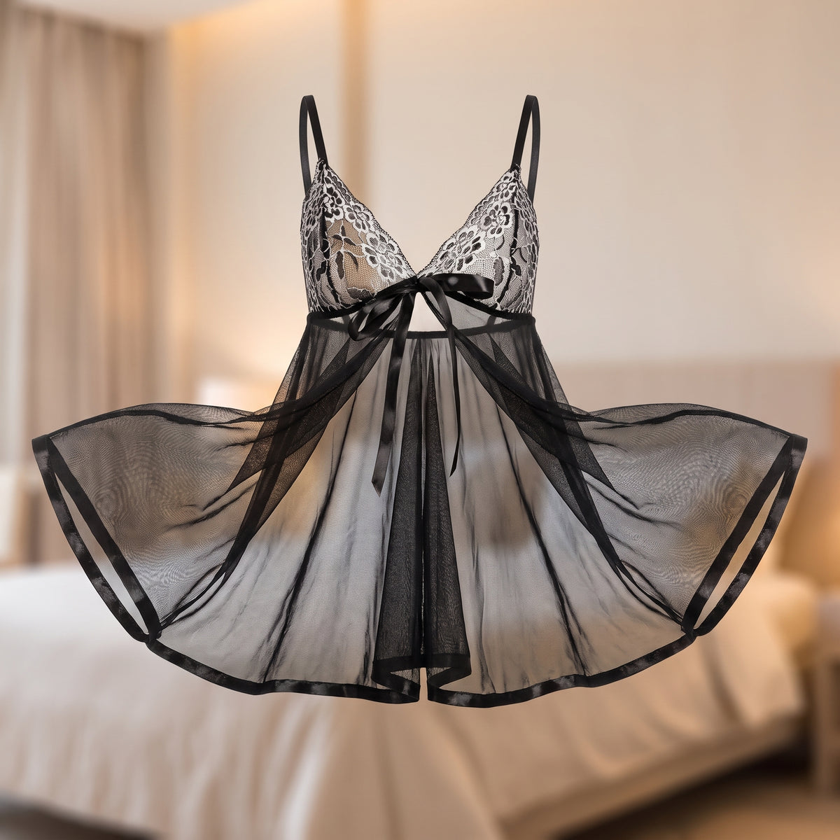 Nuisette noire sans mannequin, les deux pans de la jupe de voile écartés et ouverts devant, ourlet bordé de satin