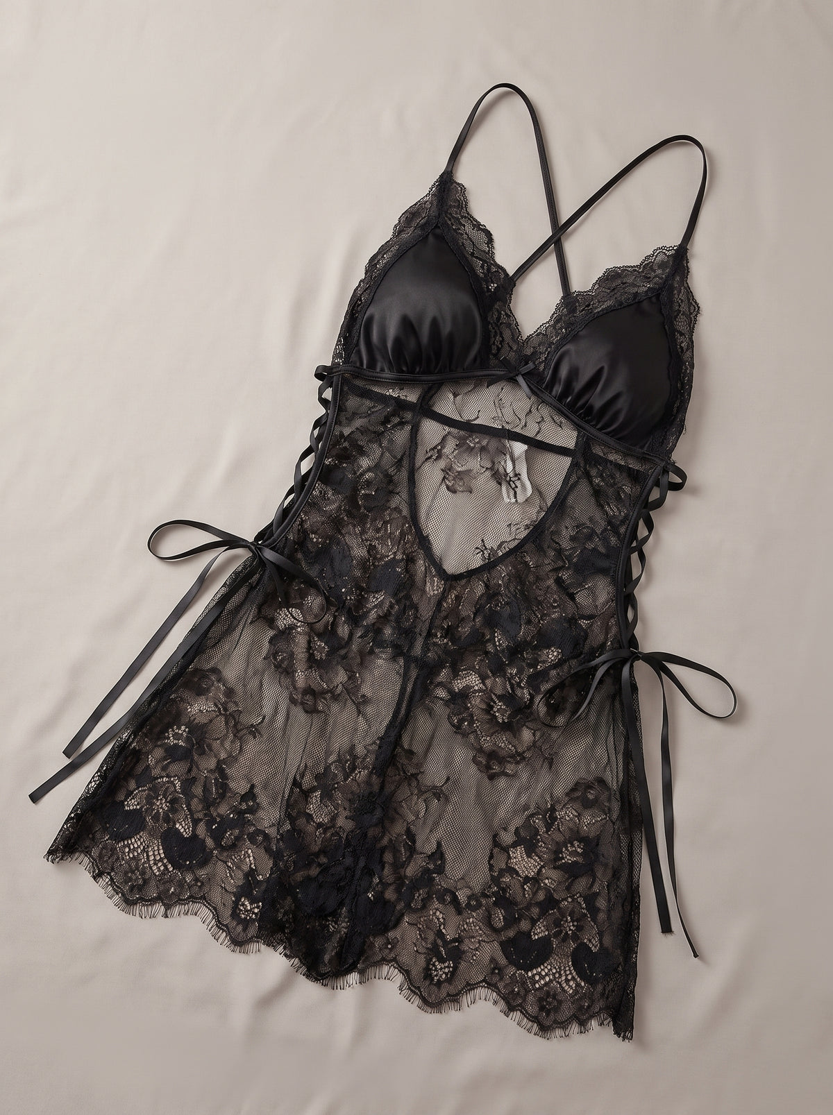 Nuisette babydoll noire en satin et dentelle fendue lacée, à plat