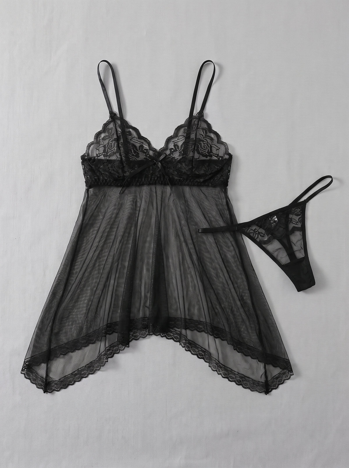 Nuisette babydoll noire en dentelle et voile transparent avec string, présentée à plat
