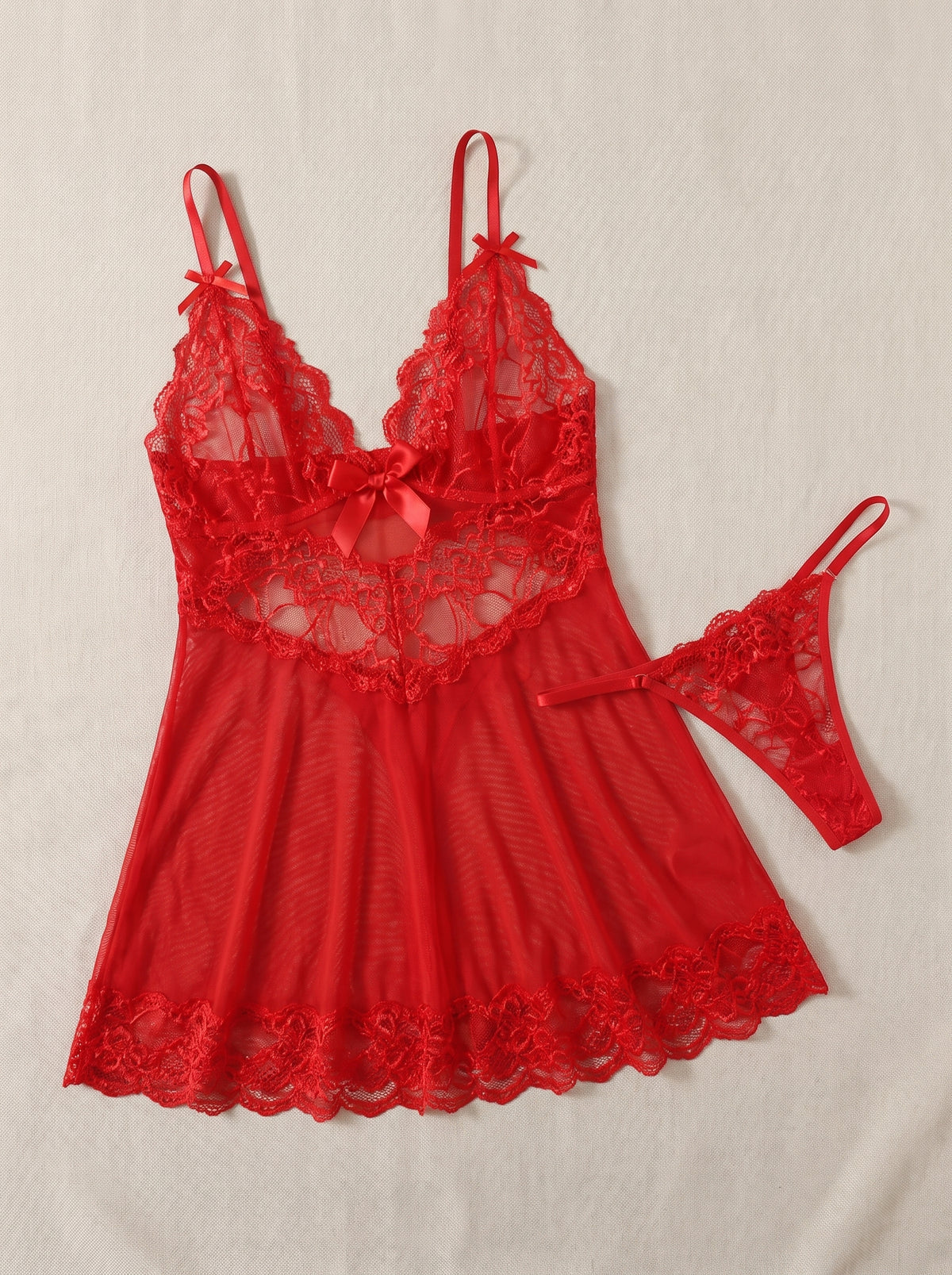 Nuisette babydoll en dentelle rouge transparente à col en V avec string, présentée à plat