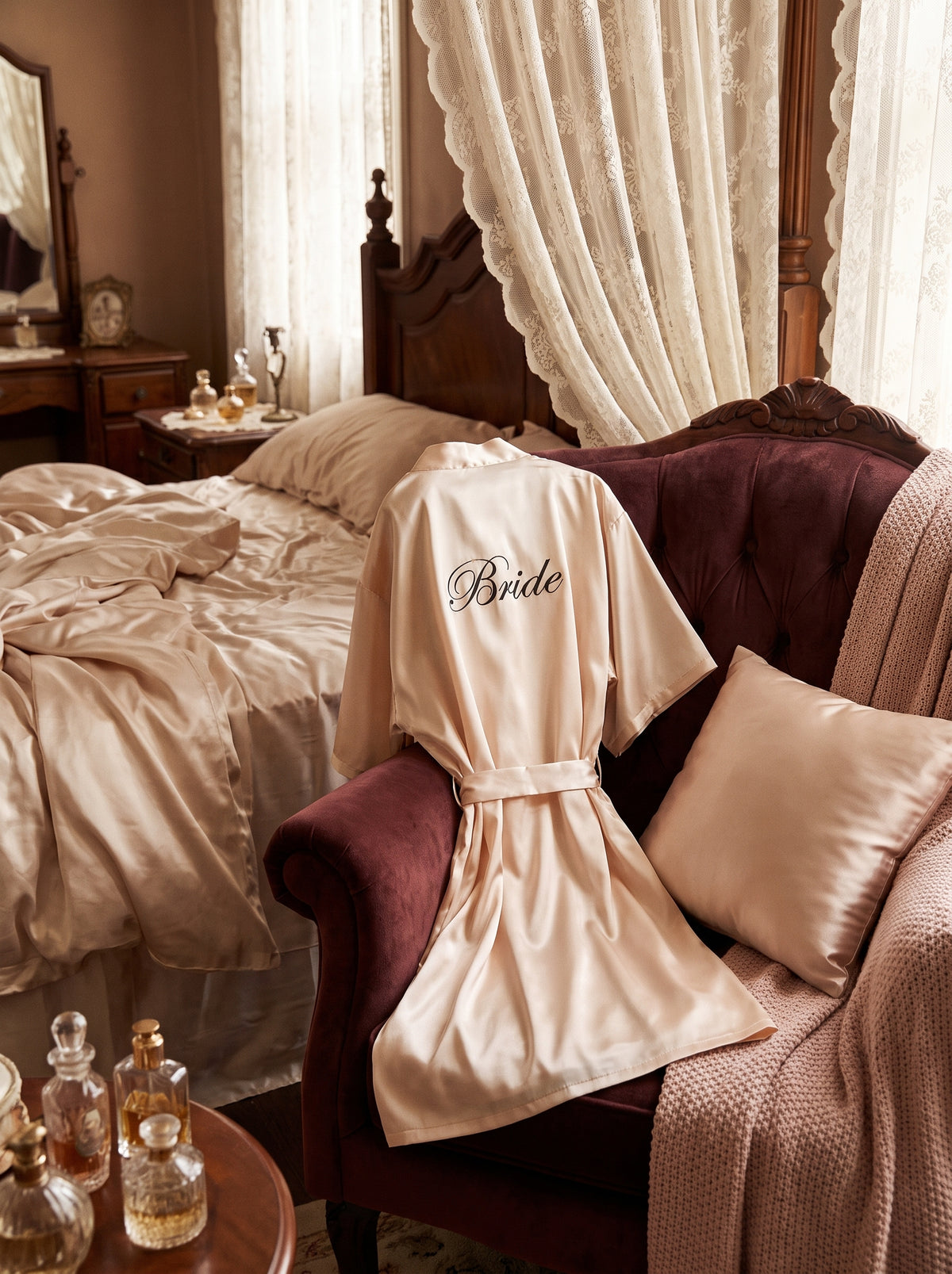 Peignoir bride beige en satin pose sur un fauteuil en velours bordeaux dans un boudoir romantique
