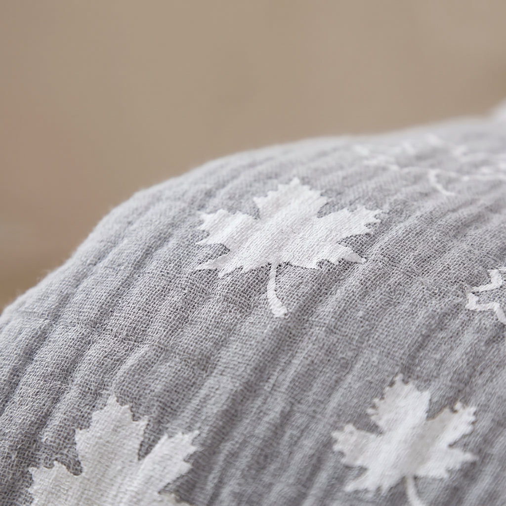 Gros plan sur la gaze de coton et le motif feuille d'erable en blanc sur fond gris