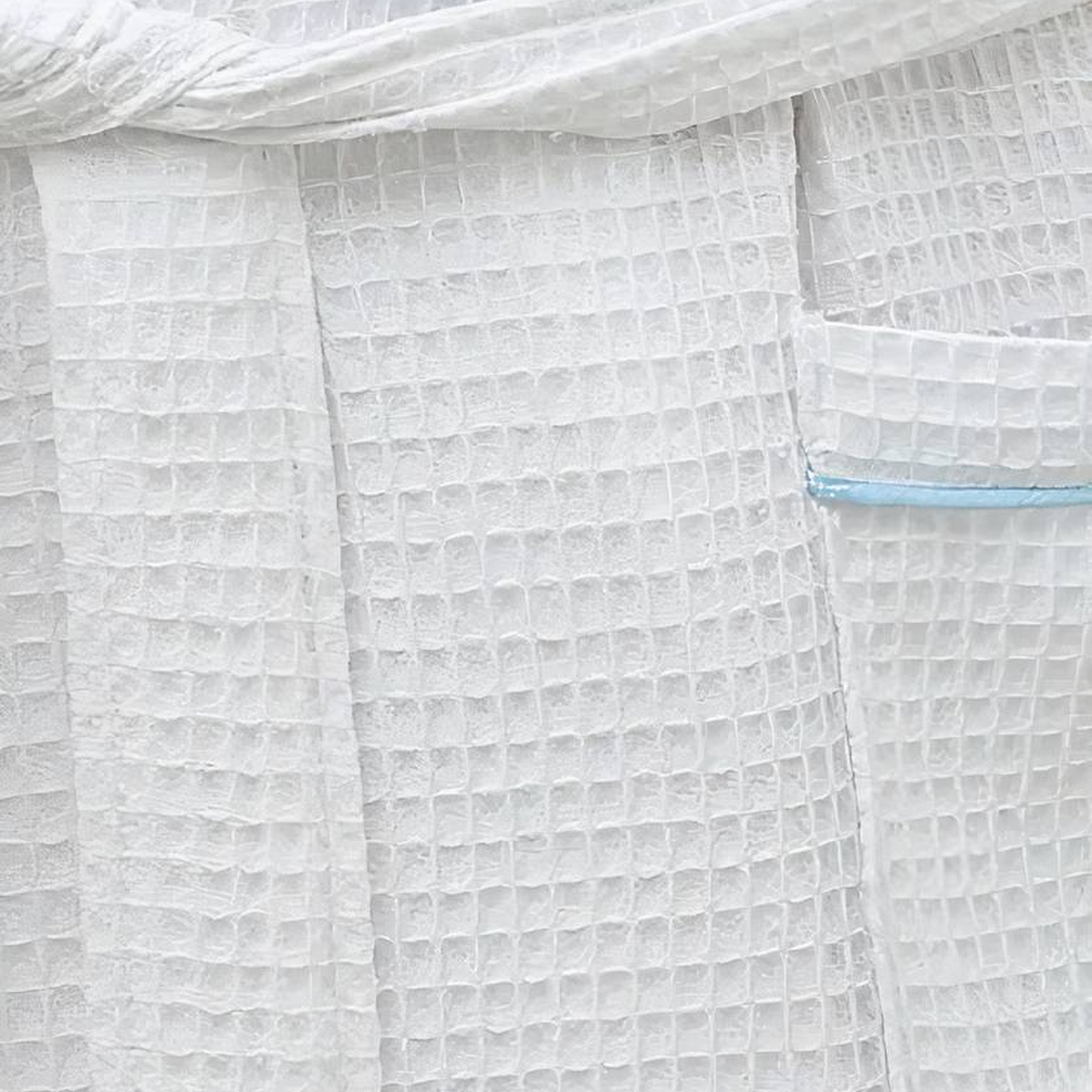 Gros plan sur la poche du peignoir gaufré et son liseré bleu clair