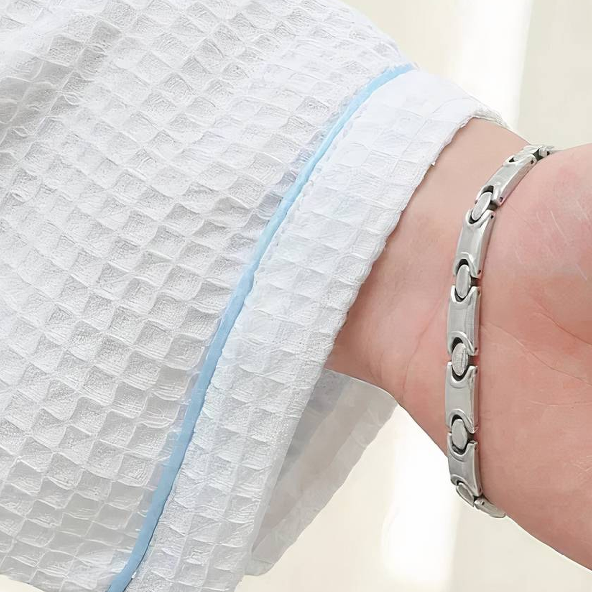 Poignet gaufré du peignoir porté après le bain, bordé d’un liseré bleu clair