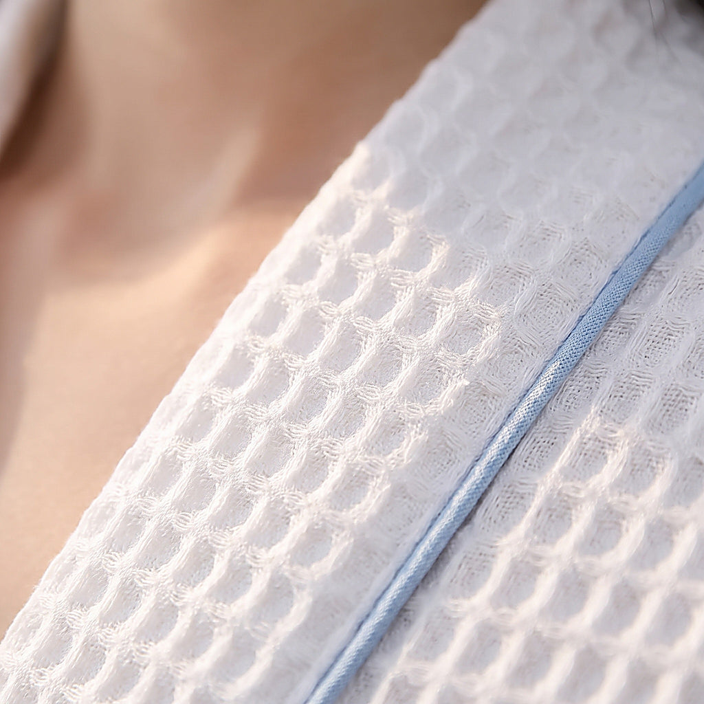 Gros plan macro sur la texture gaufree nid d'abeille du peignoir hotel blanc en coton
