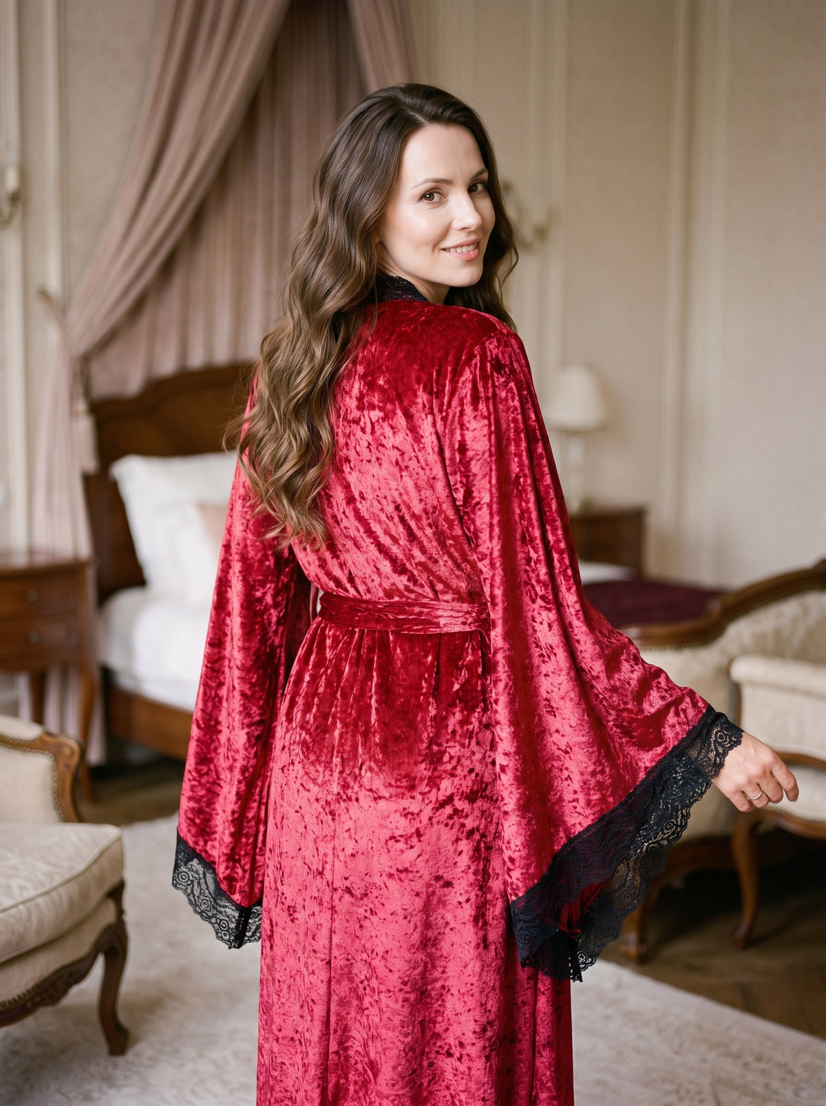 Dos du peignoir kimono long rouge en velours porté, ceinture à la taille et manches évasées bordées de dentelle noire