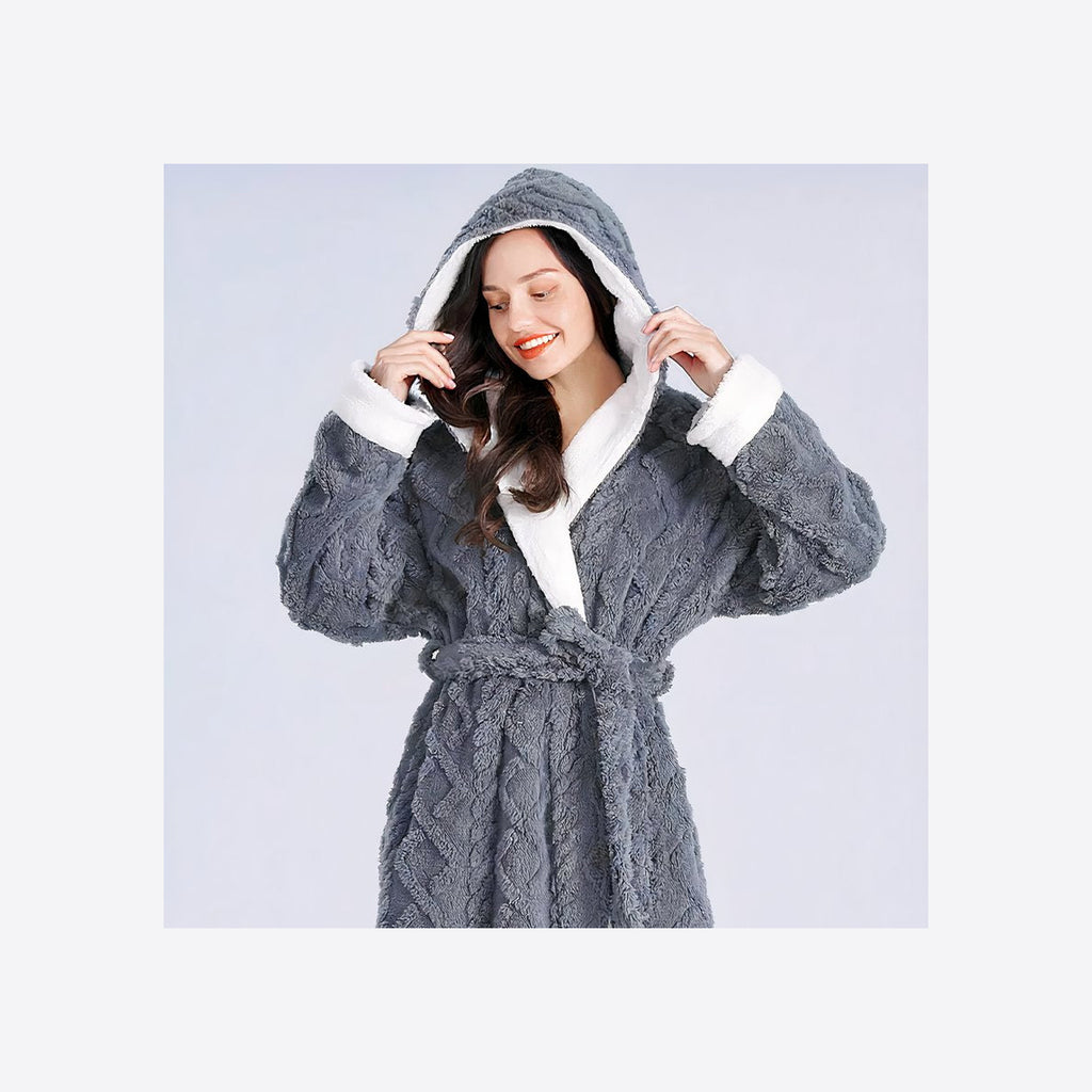 Femme souriante relevant la capuche du peignoir polaire gris