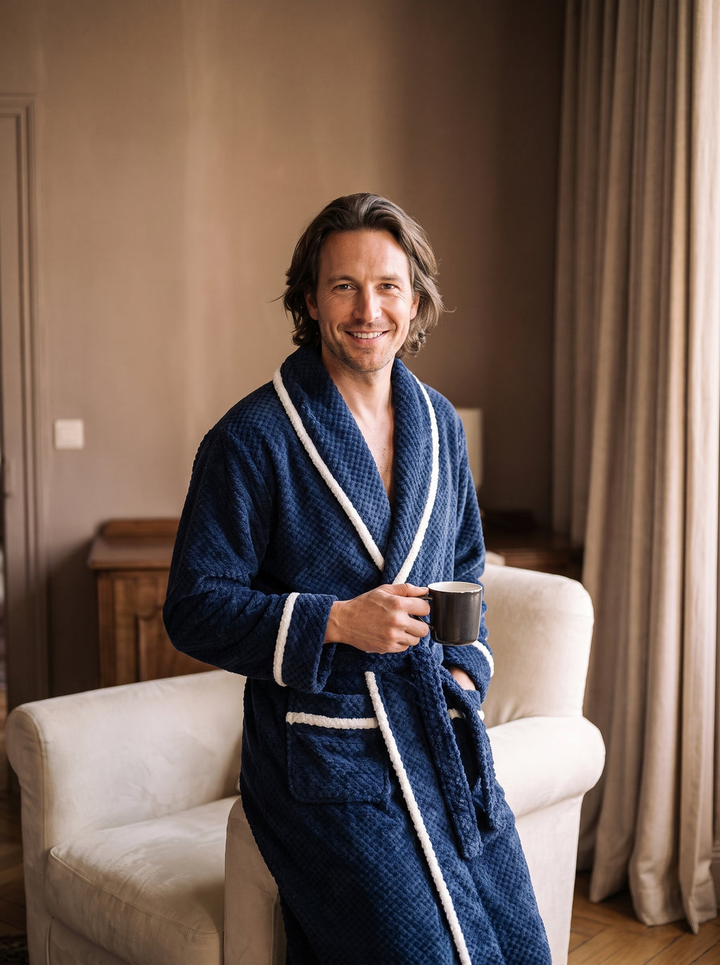 Homme souriant portant le peignoir bleu marine long à capuche et liserés blancs
