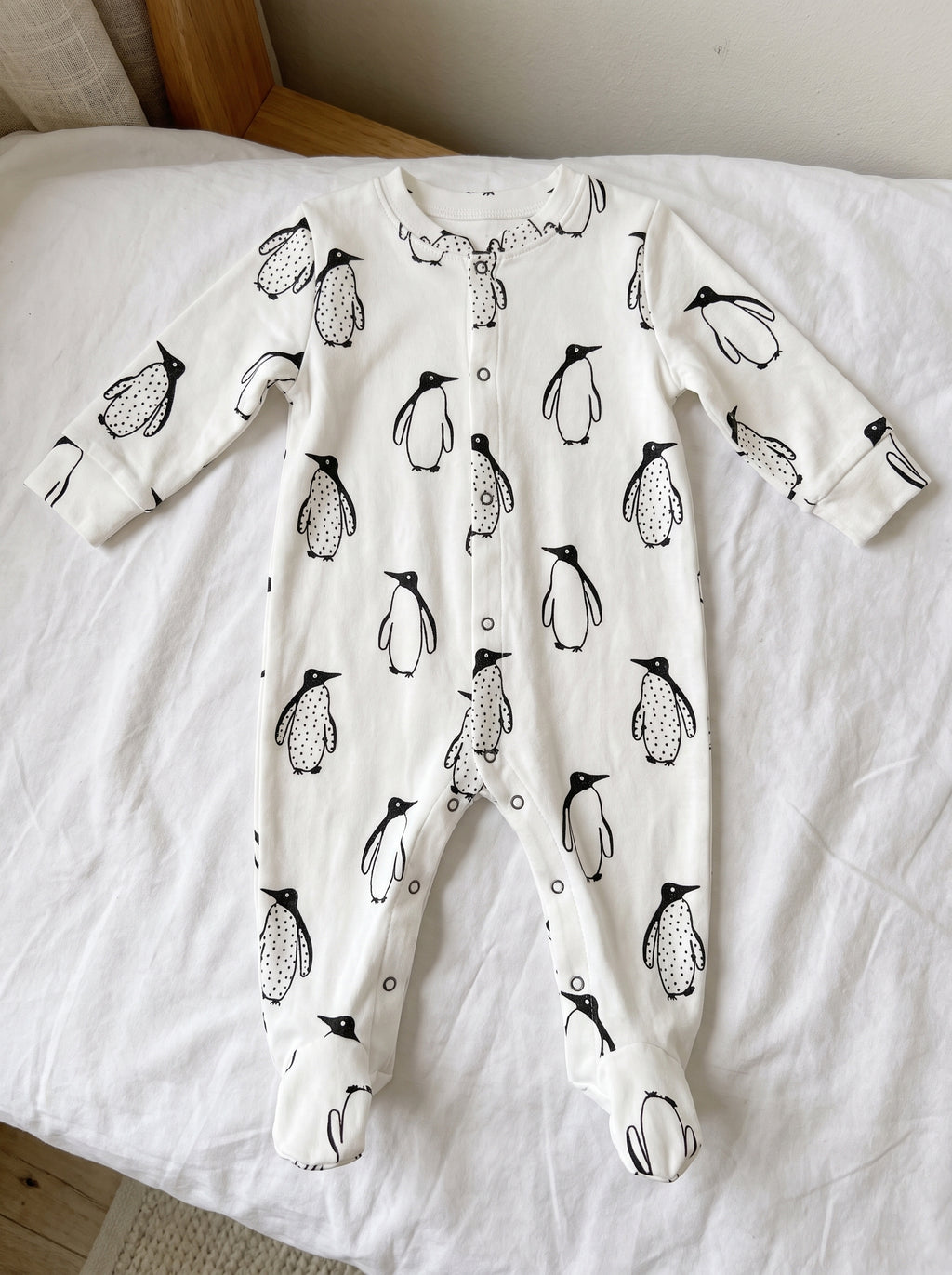 Combinaison pyjama bébé à pingouins vue de face à plat, du col aux pieds