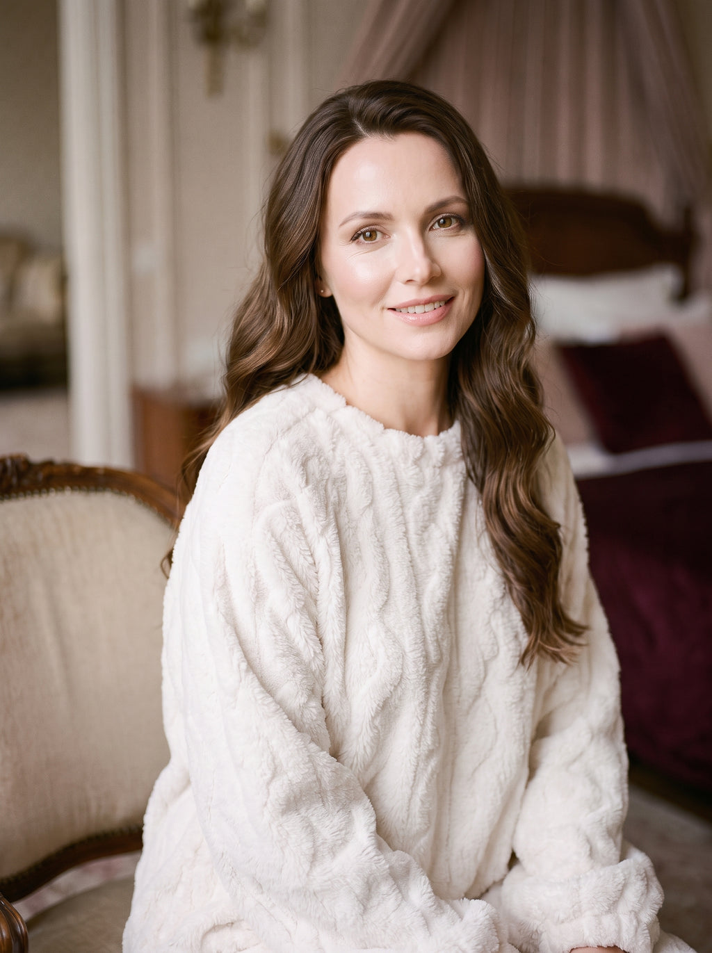 Robe de nuit blanche en polaire texturee portee par un modele souriant, cadrage mi-cuisse, decor boudoir
