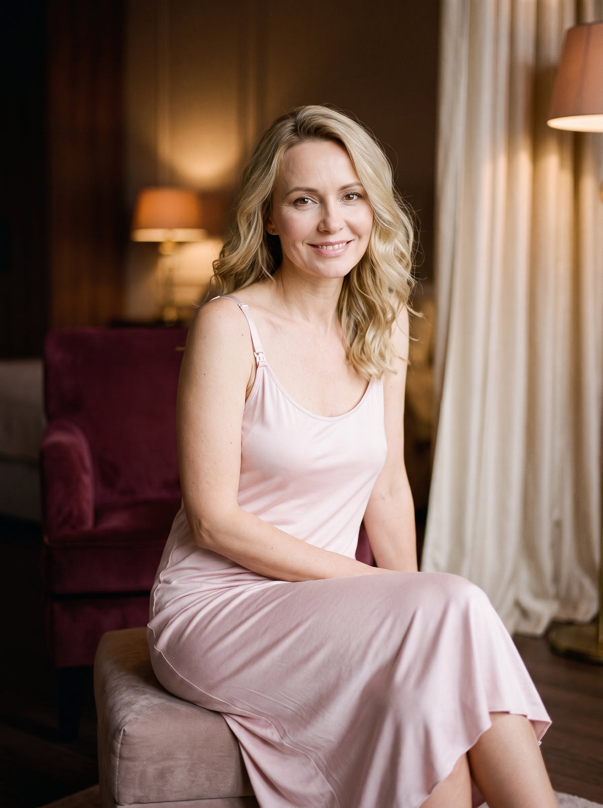 Nuisette d'allaitement rose portée, modèle souriant dans un boudoir élégant, coupe longue fluide