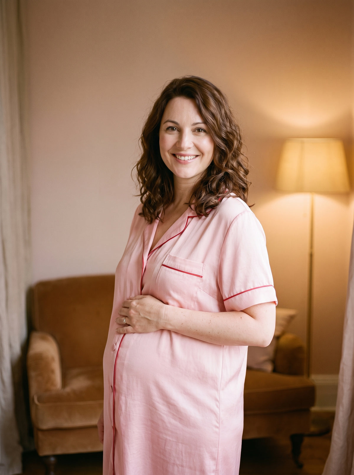 Femme enceinte souriante portant la chemise de nuit vintage rose poudrée