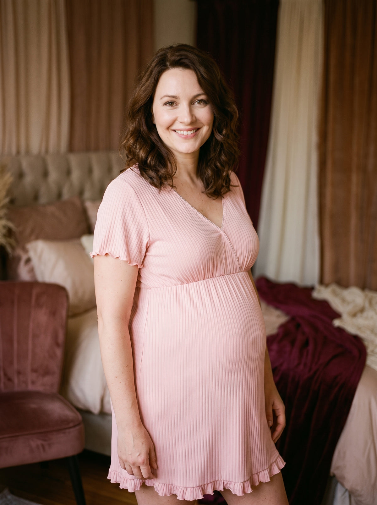Future maman souriante portant la chemise de nuit maternité rose à manches courtes