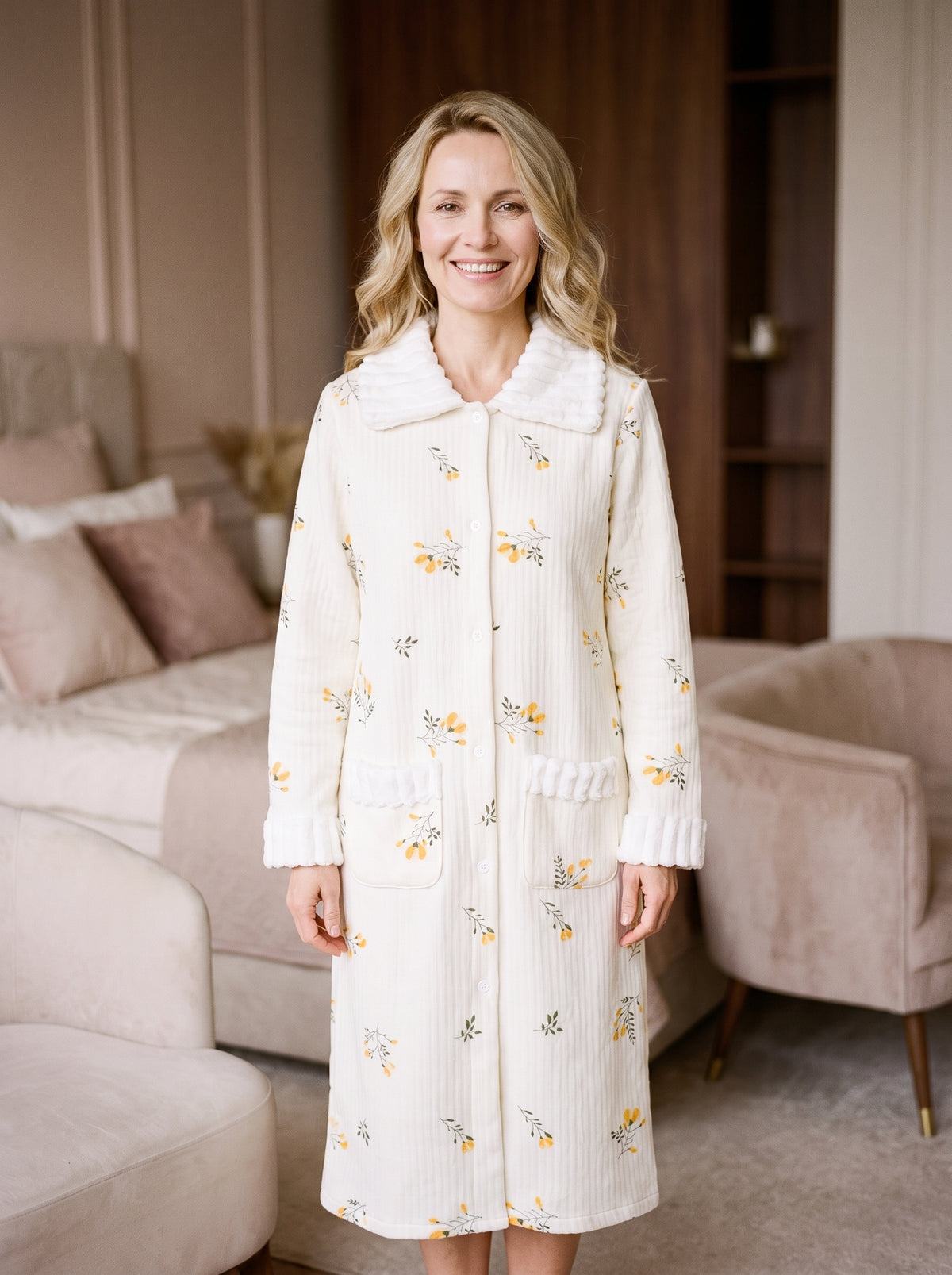 Robe de chambre boutonnée en coton à motifs fleuris portée par une femme blonde souriante