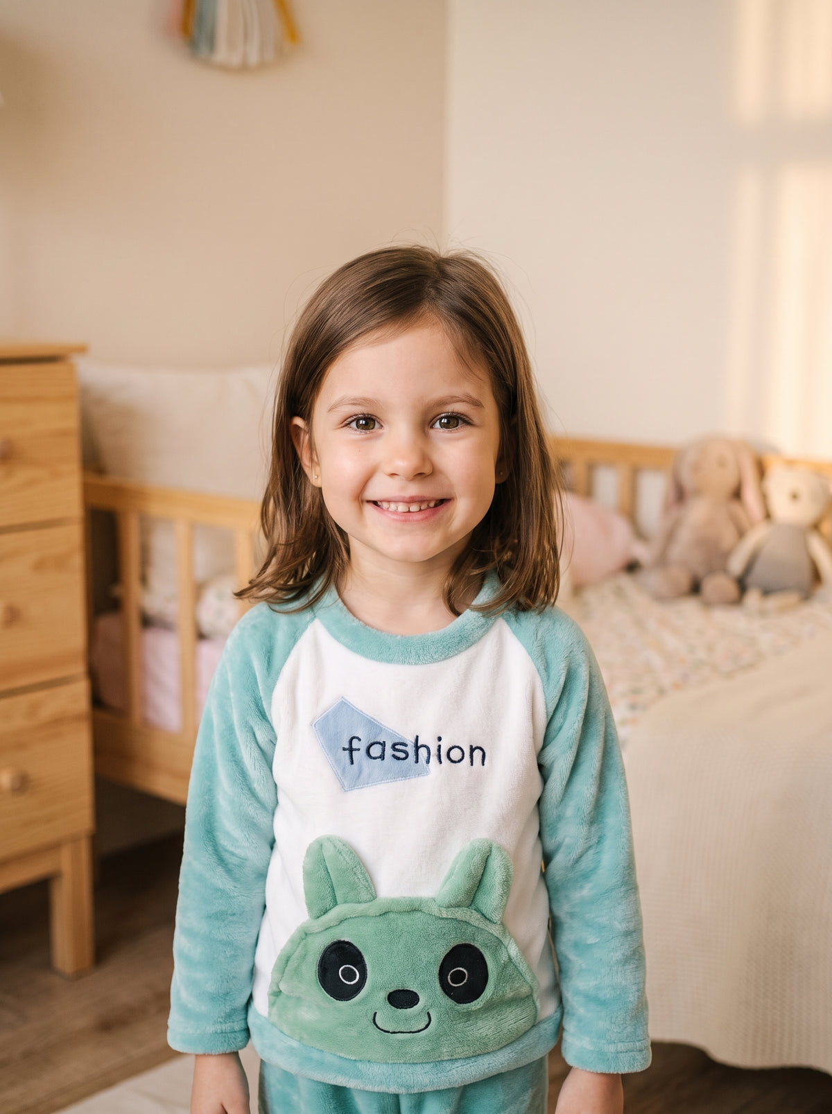 Petite fille portant le pyjama vert d'eau avec badge fashion et poche panda