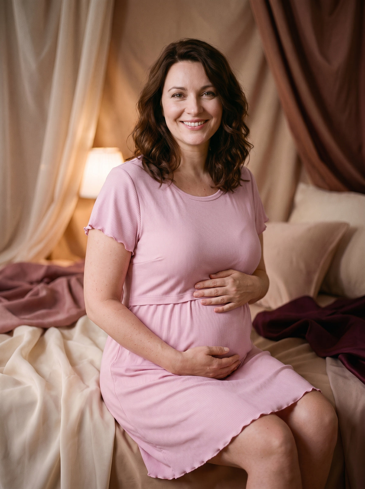 Nuisette de maternité rose poudré portée par une future maman souriante, col rond et taille empire