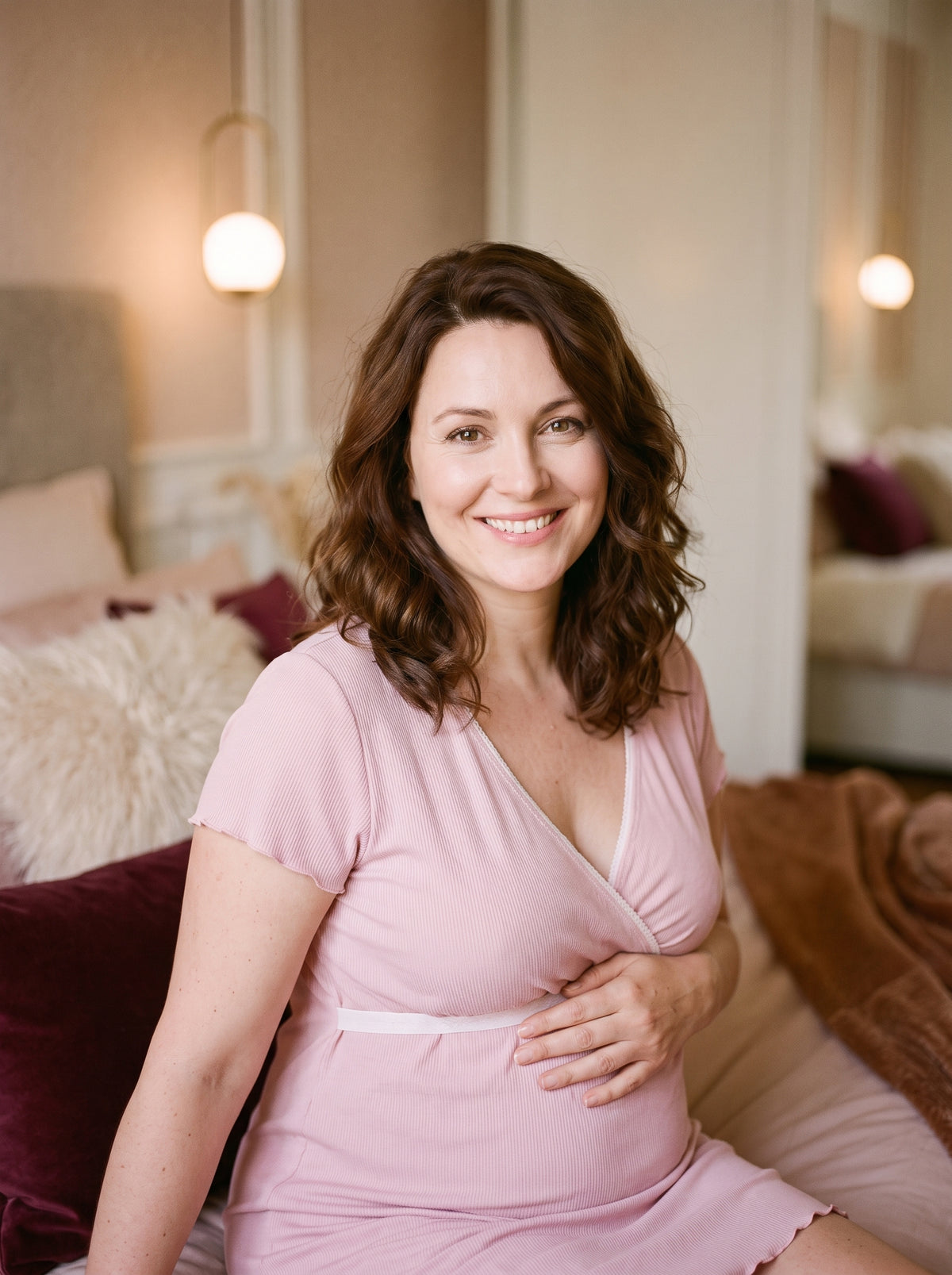 Nuisette de maternité rose poudré portée par une future maman souriante, encolure cache-cœur