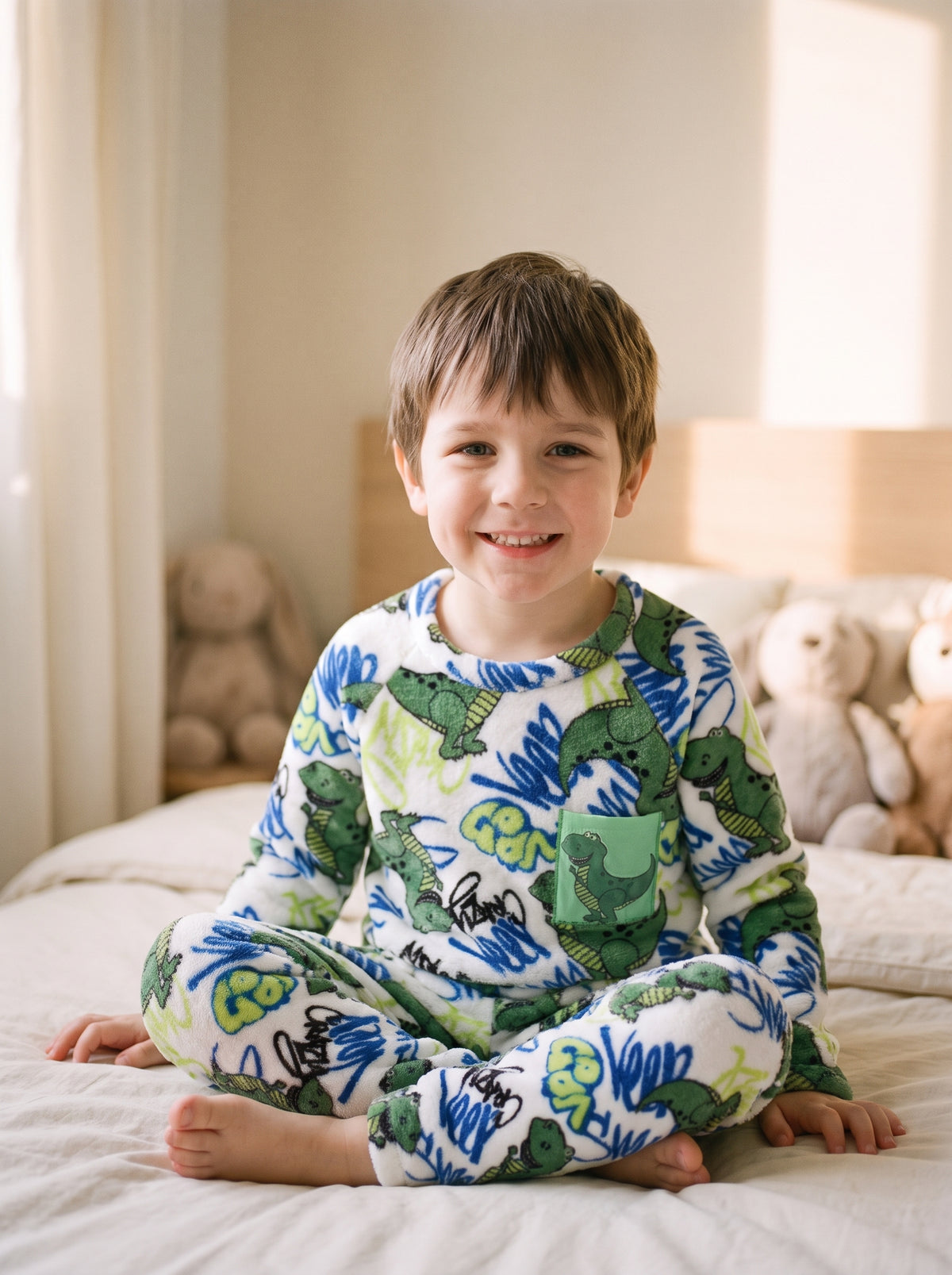 Pyjama garcon en flanelle a dinosaures imprimes, porte par un enfant assis sur son lit