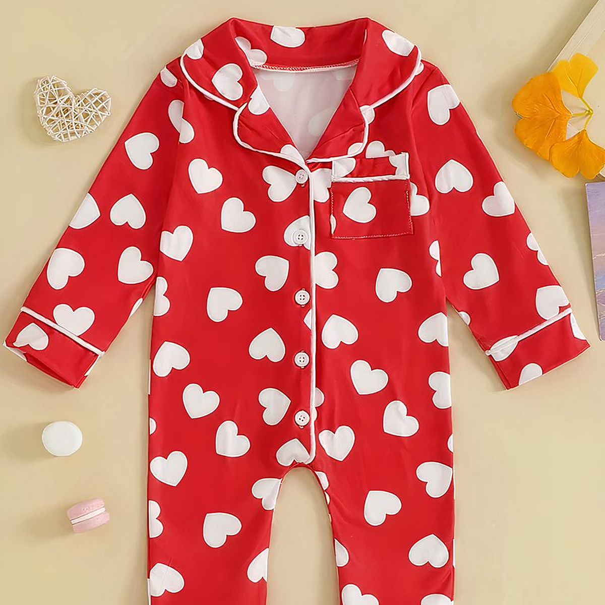 Pyjama bébé rouge à cœurs blancs vu de face, col, poche et cinq boutons visibles