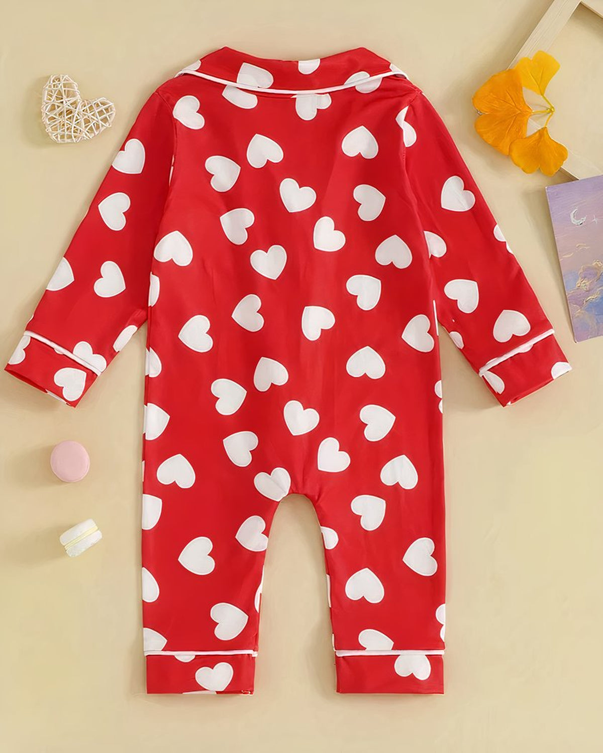 Dos du pyjama bébé rouge à cœurs blancs, manches et jambes déployées