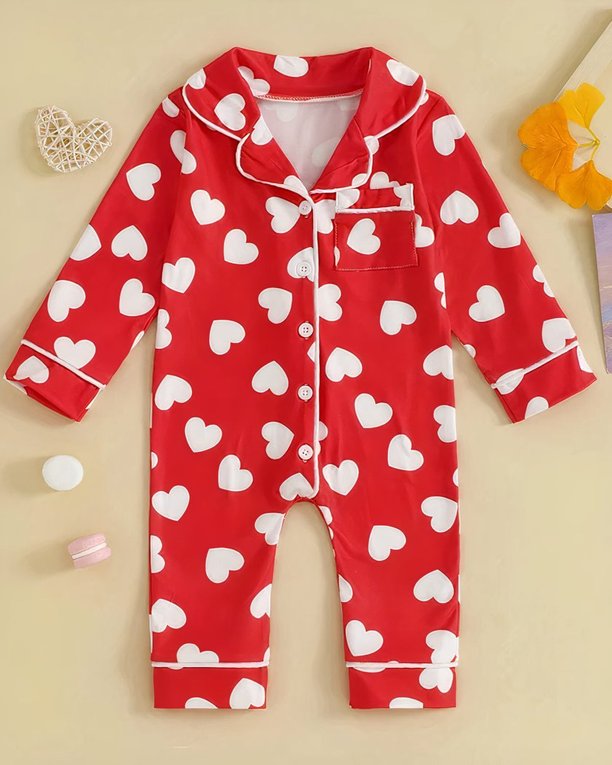 Pyjama bébé rouge à cœurs blancs posé à plat, vu de face