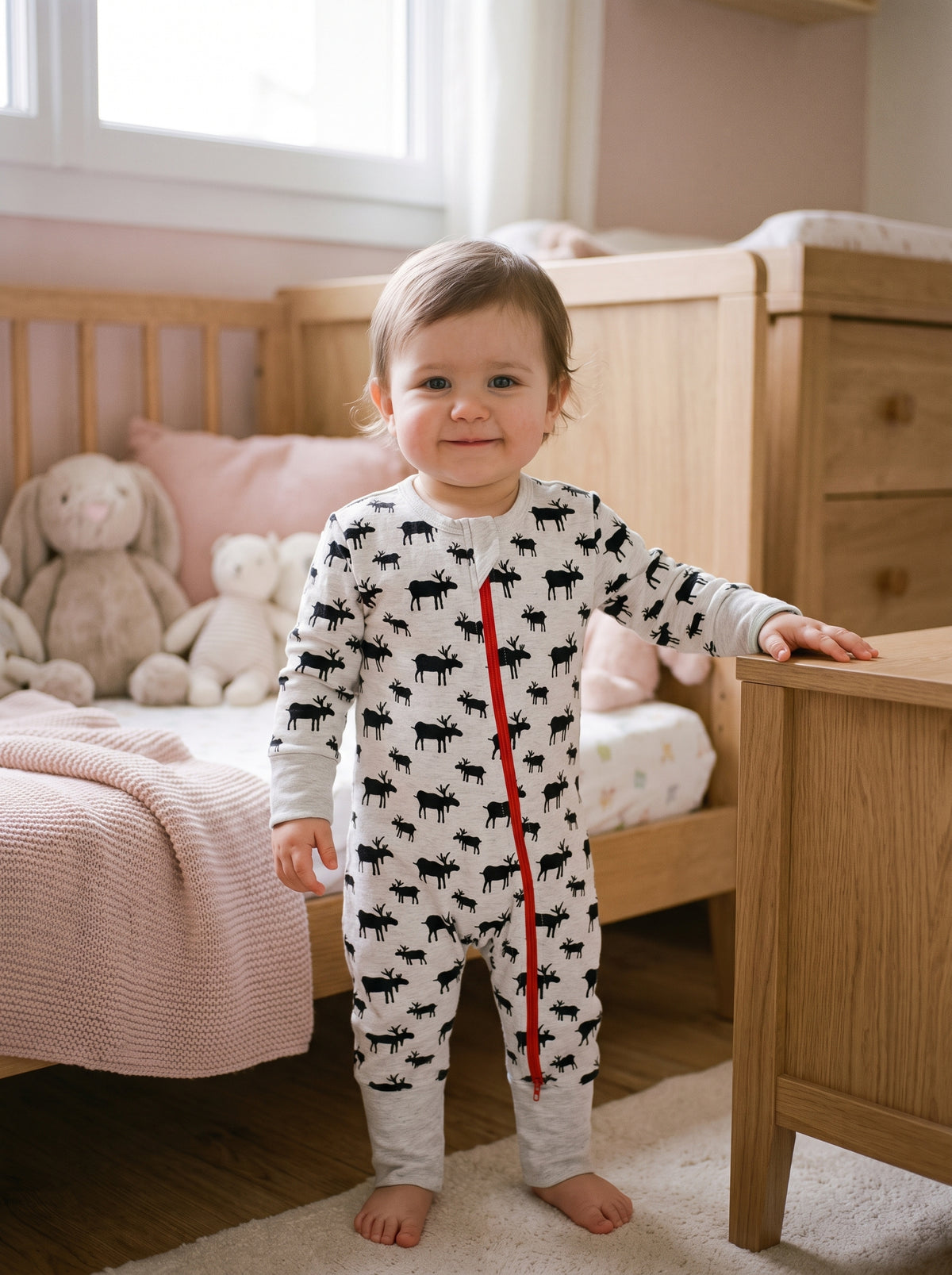 Bébé debout dans une chambre portant le pyjama gris clair à motifs de rennes