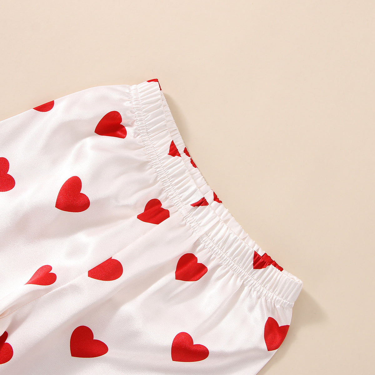 Gros plan sur la taille elastiquee du pantalon et le satin a coeurs rouges