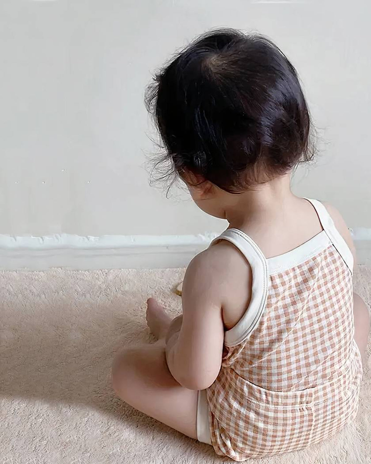 Vue de dos du pyjama bébé d’été rose à carreaux, bretelles et short