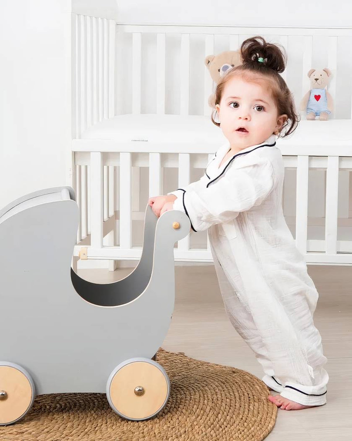 Bébé debout au réveil dans son pyjama blanc à manches et jambes longues
