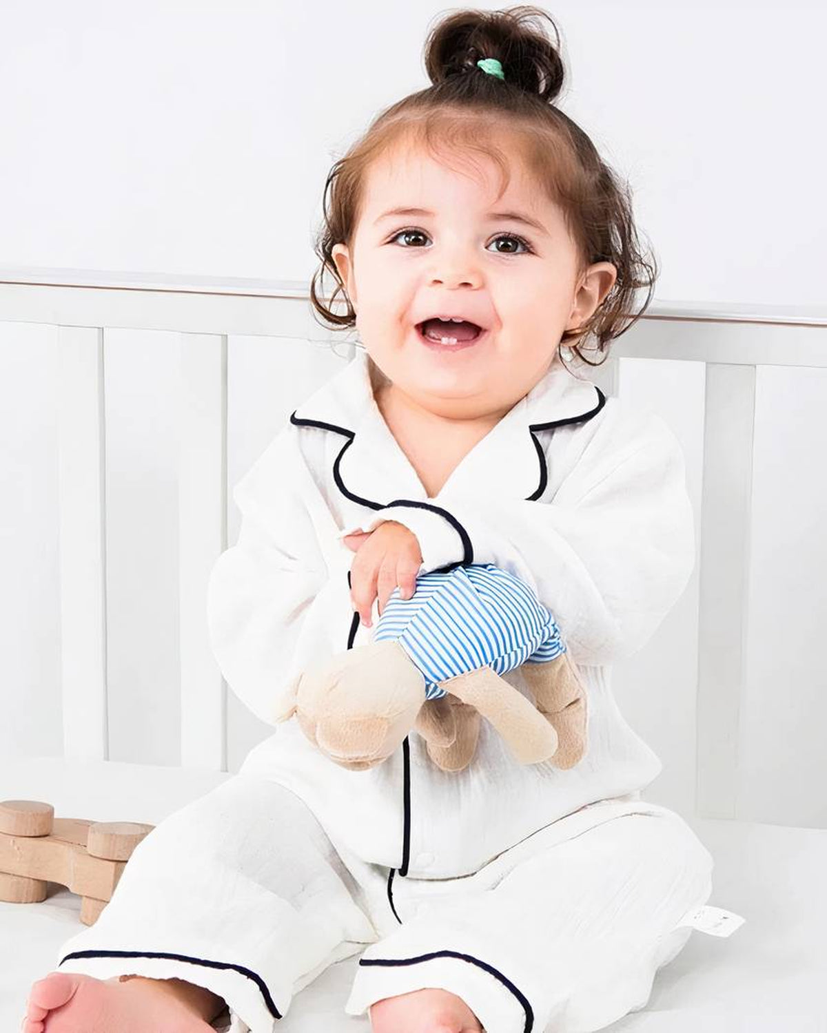 Bébé souriant portant le pyjama en mousseline de coton blanc à liserés noirs