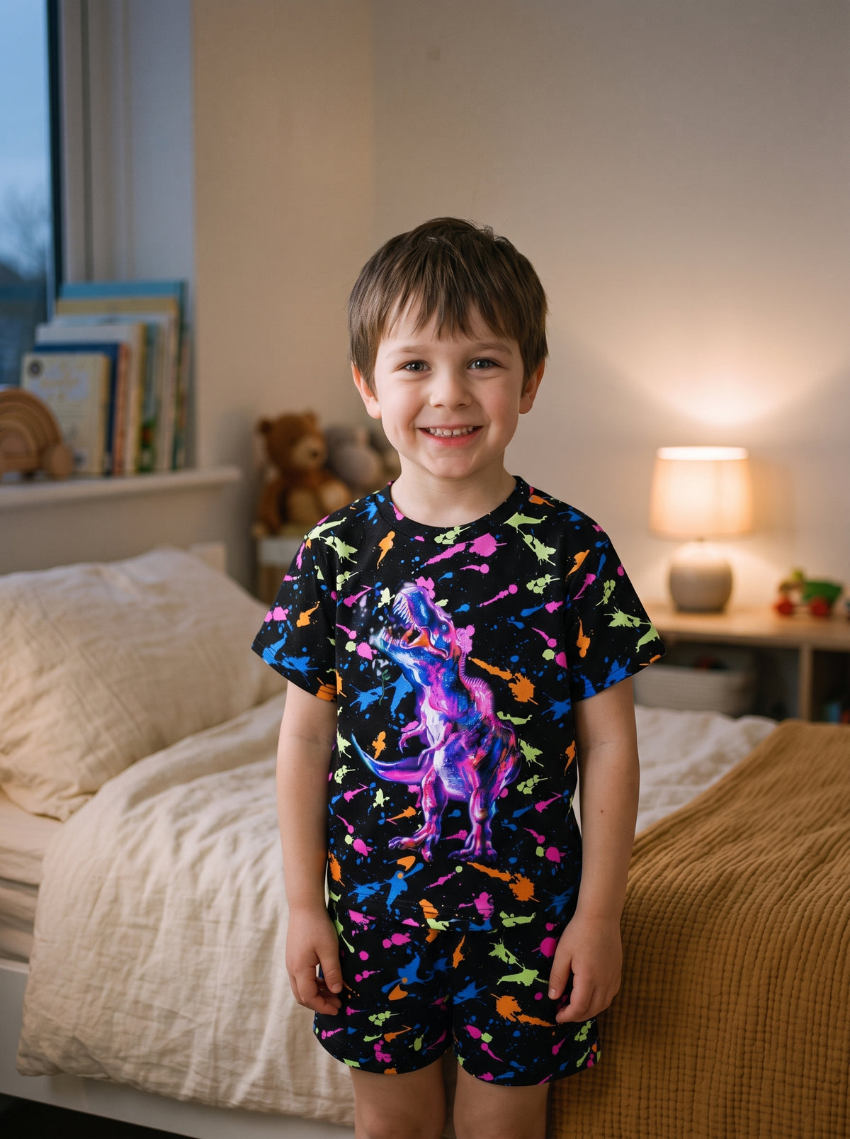 Garçon debout dans sa chambre en pyjama dinosaures, tee-shirt et short assortis
