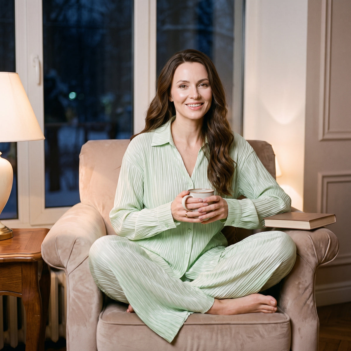 Rituel du soir d'hiver dans un fauteuil, une tasse à la main, en pyjama femme hiver vert plissé deux pièces