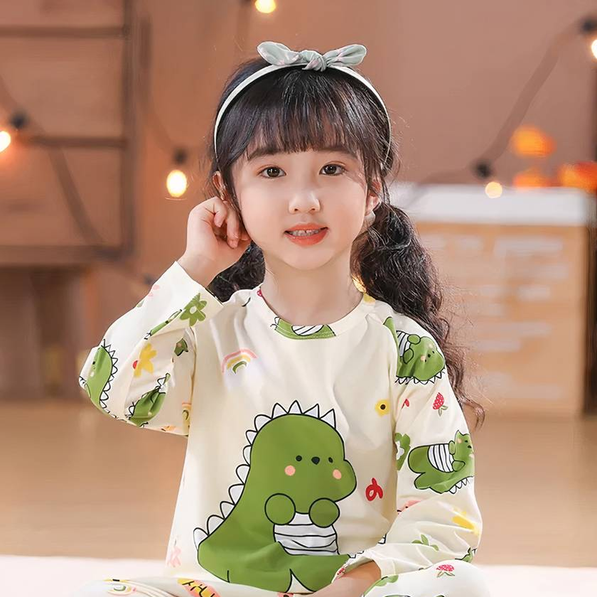 Fille prête pour le coucher dans son pyjama dinosaure vert